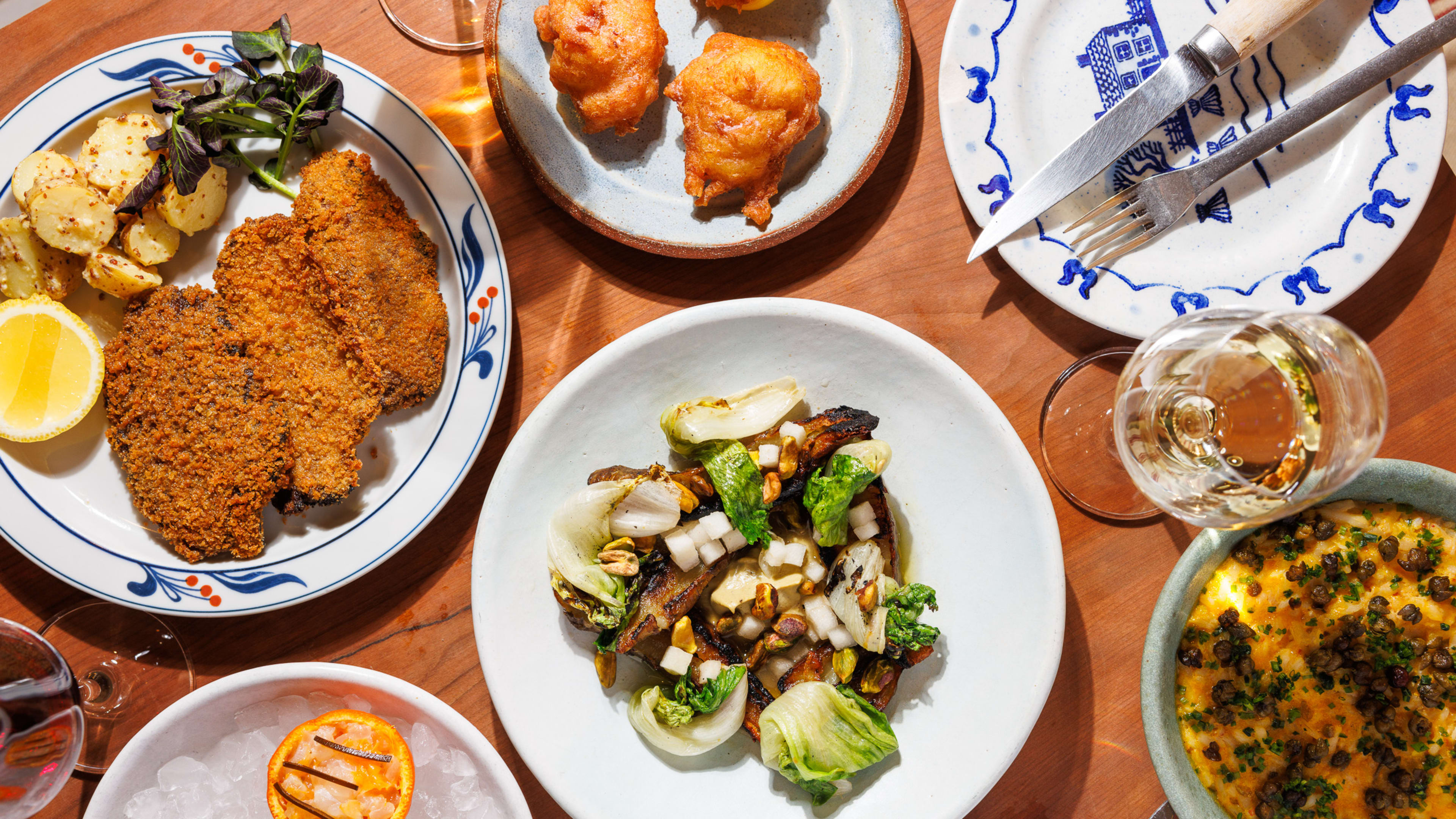 a spread of dishes at gem wine, including mushroom schnitzel, roasted sunchokes, a fluke crudo, and a salt cod beignet