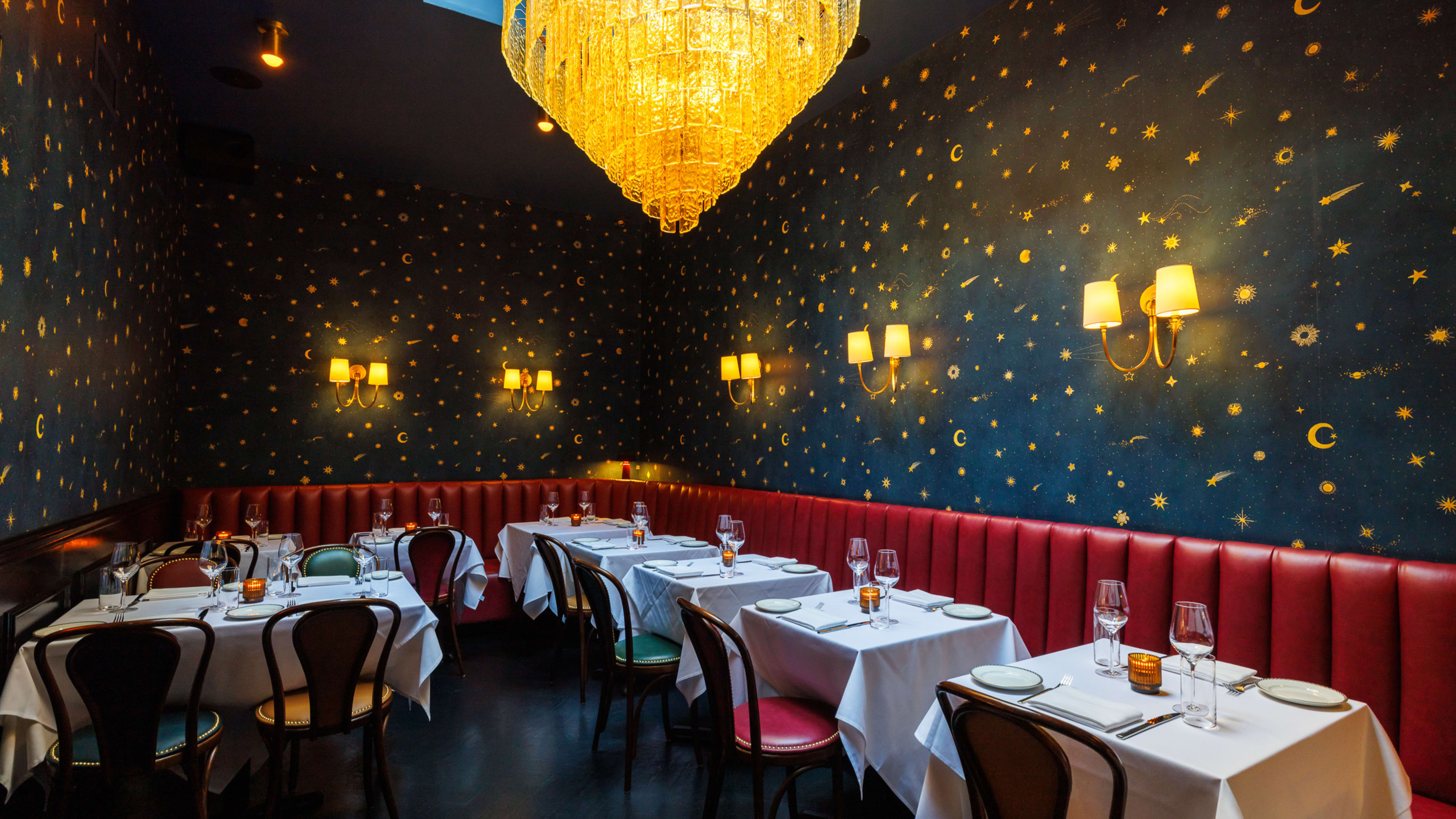 The dining room at Hoexter's, with a large chandelier and stars-and-moons wallpaper