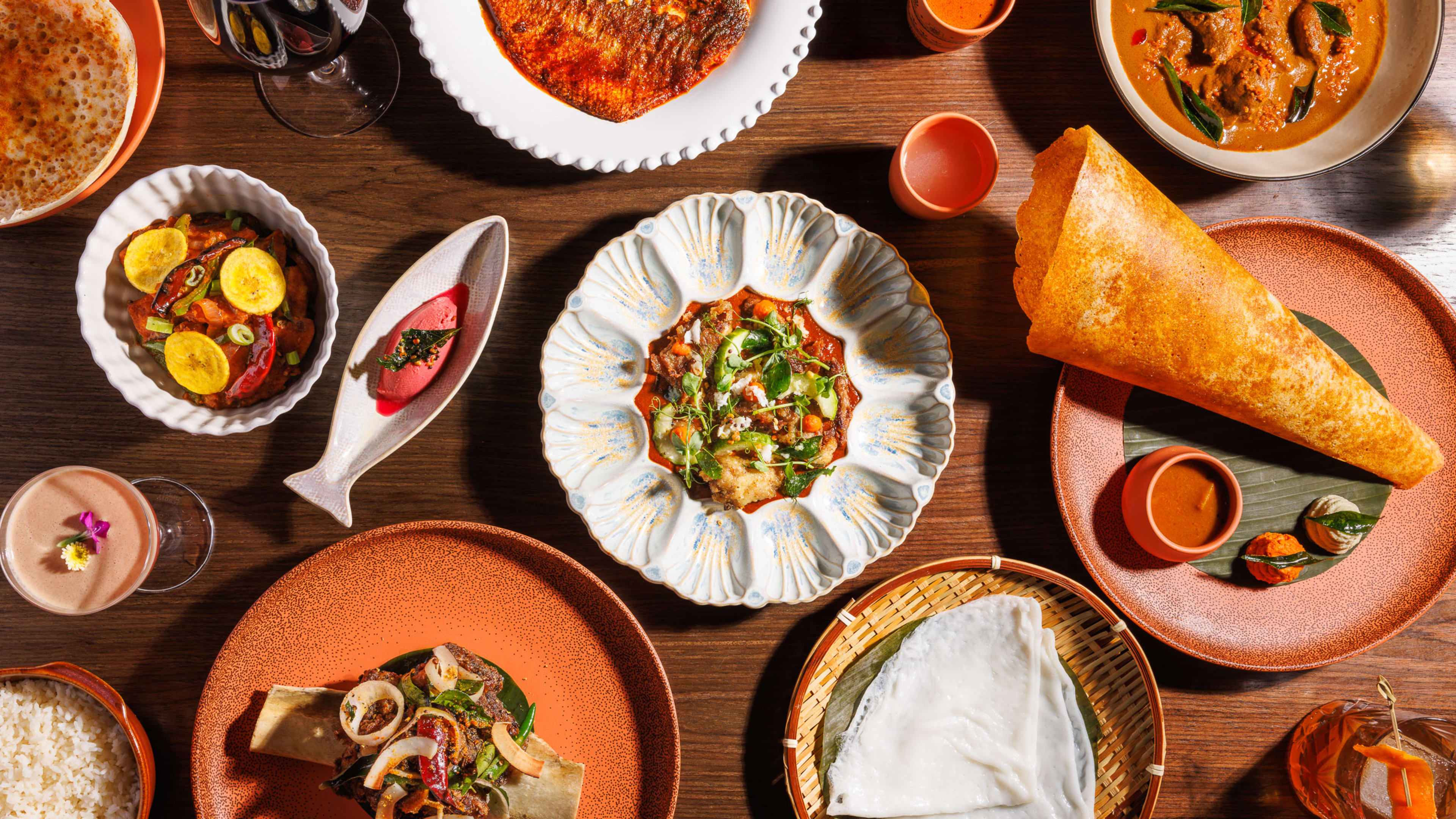 a spread of dishes at kanyakumari, including a dosa, a sorbet, and some curries