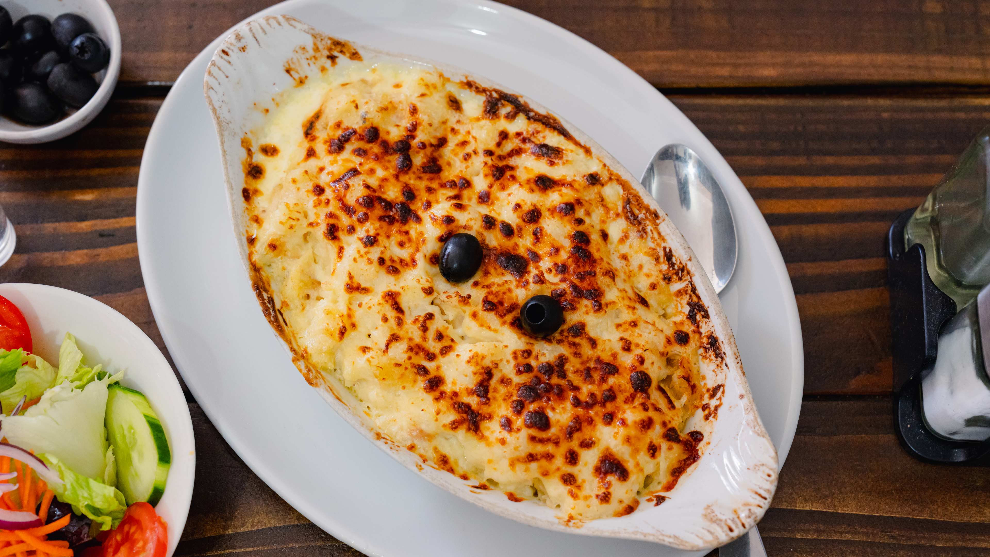 Overhead shot of a white dish with bacalhau com natas.