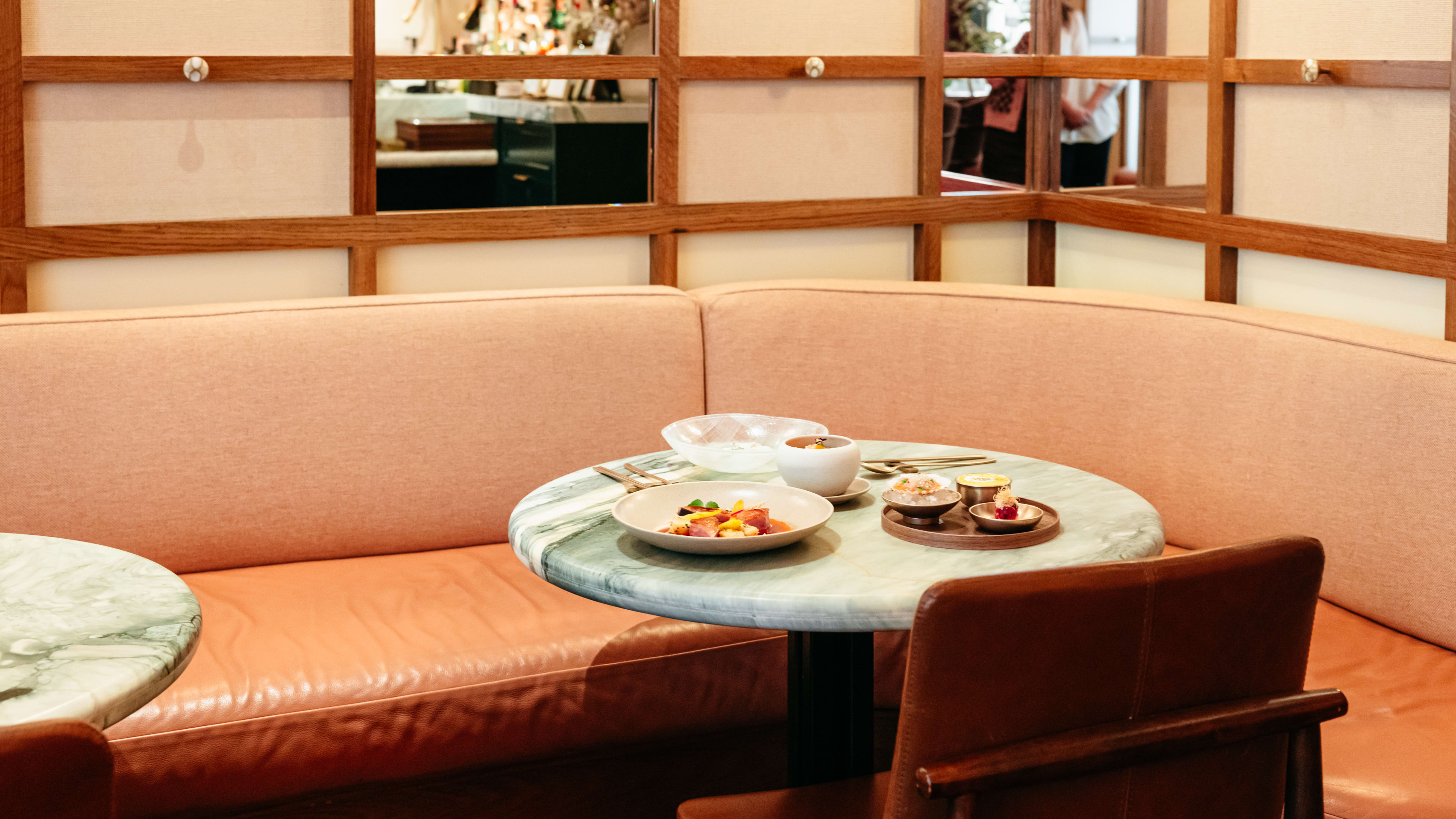 A pink couch and table with food.