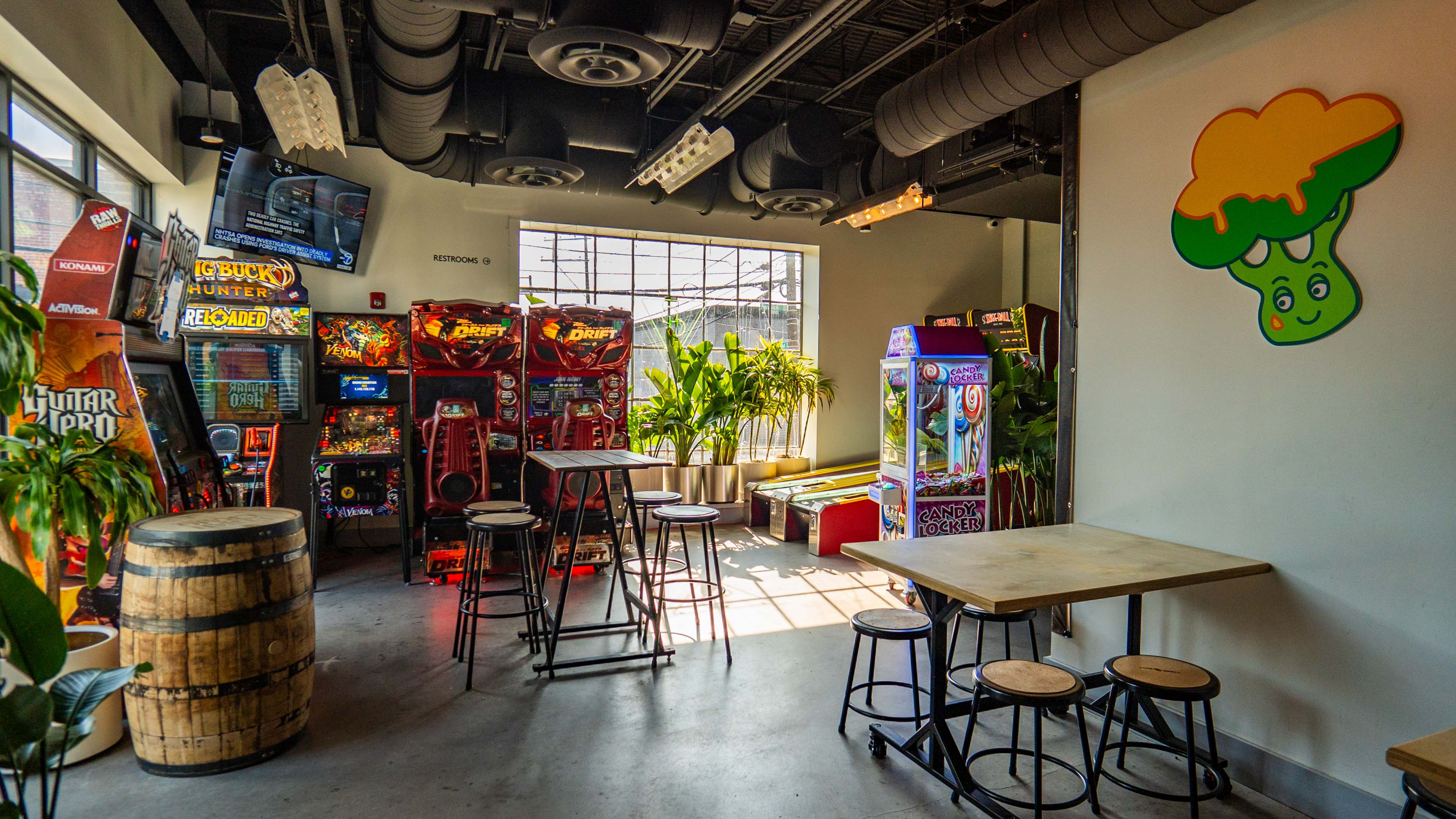 arcade room with cheesy broccoli wall art and tables