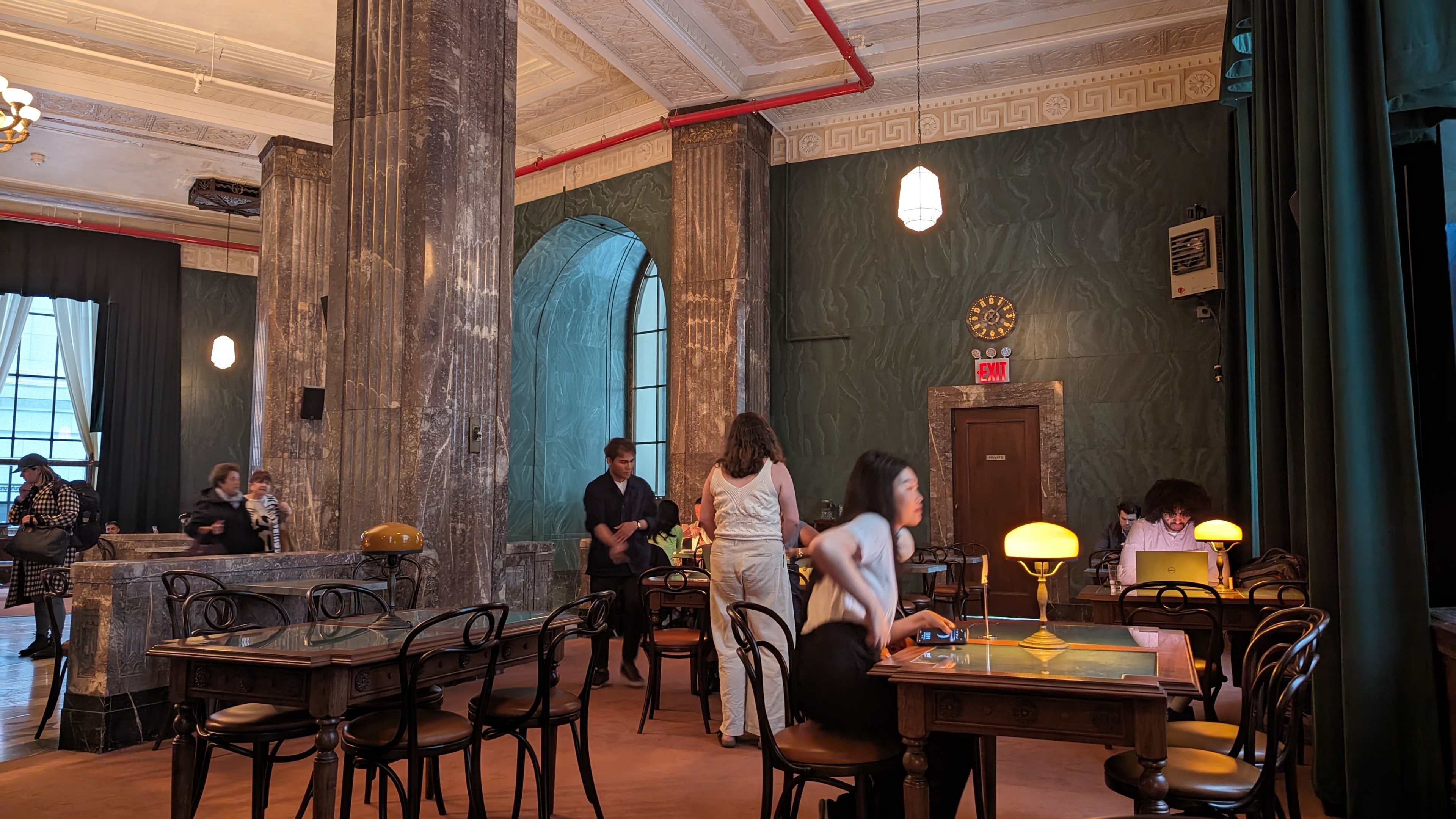 view of the room with green curtains and grey marble columns