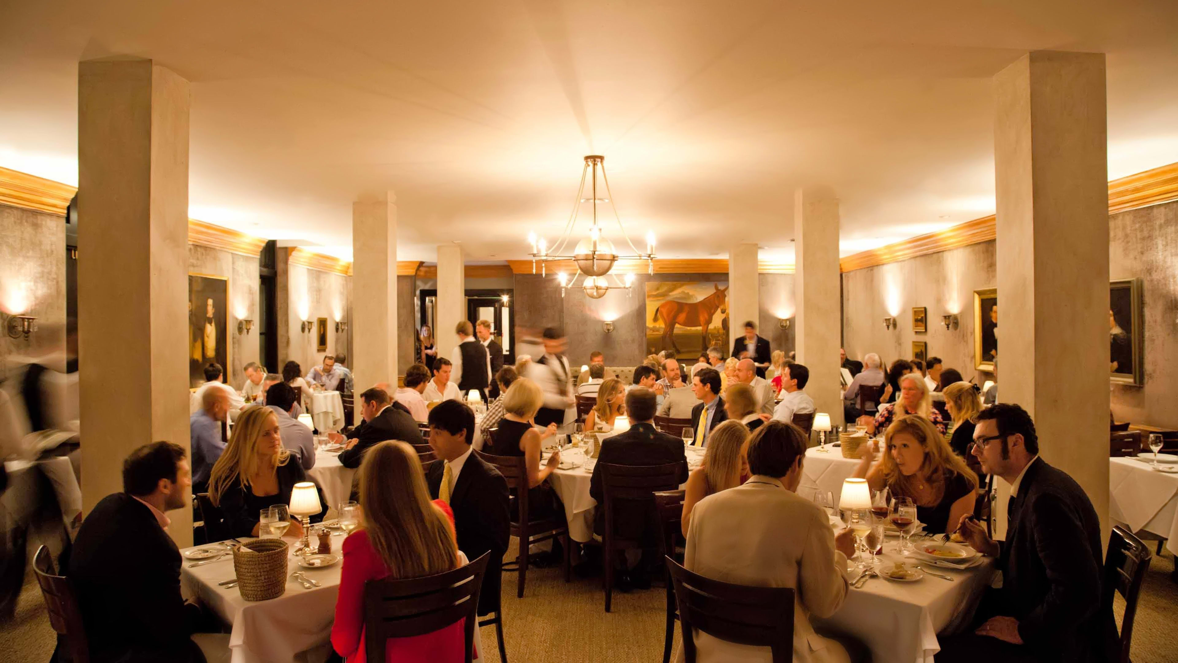 A full dining room with tables of people dressed nicely for dinner at Peninsula Grill in Charleston.