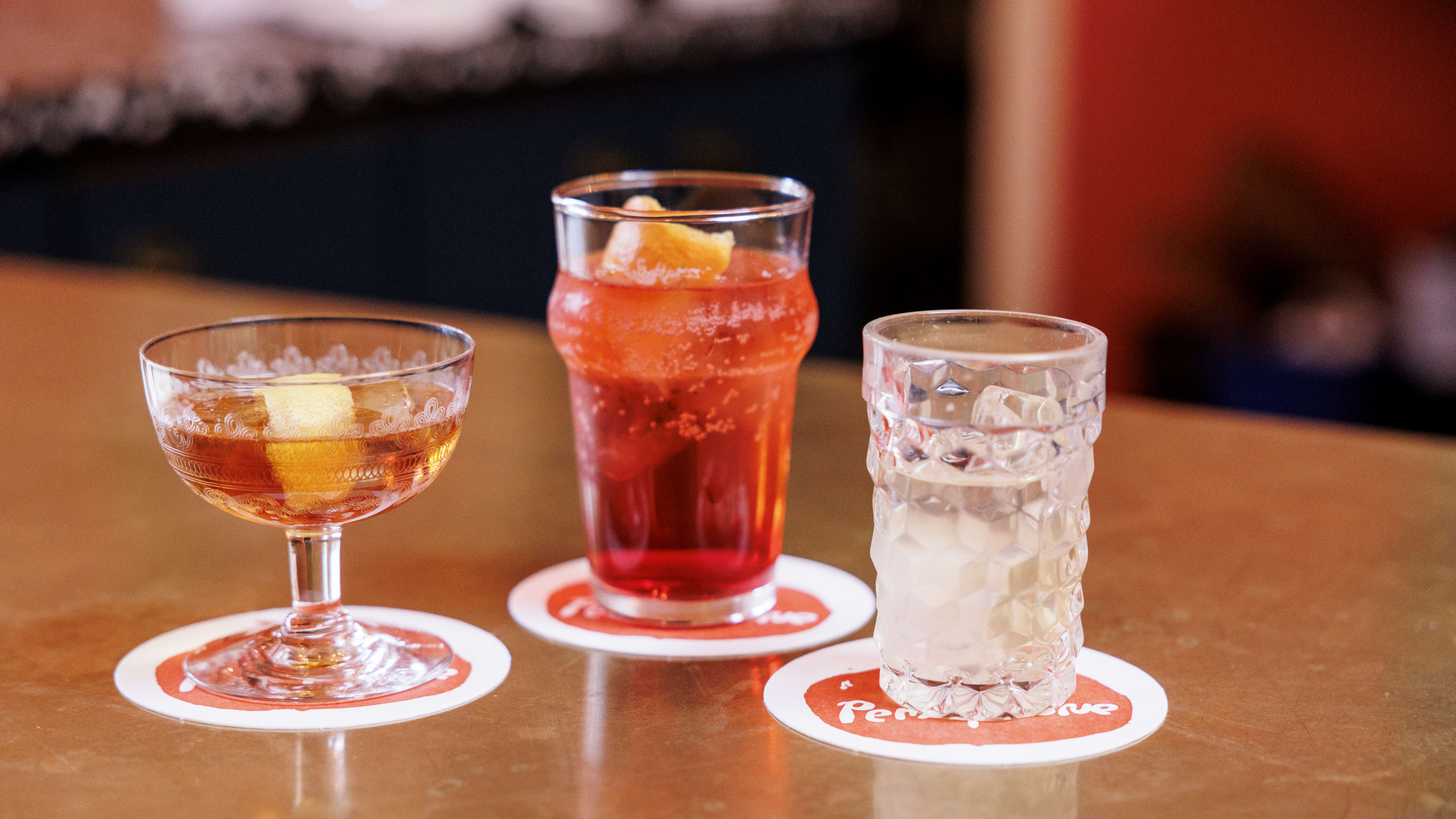 Three different cocktails in different glasses on the bar.