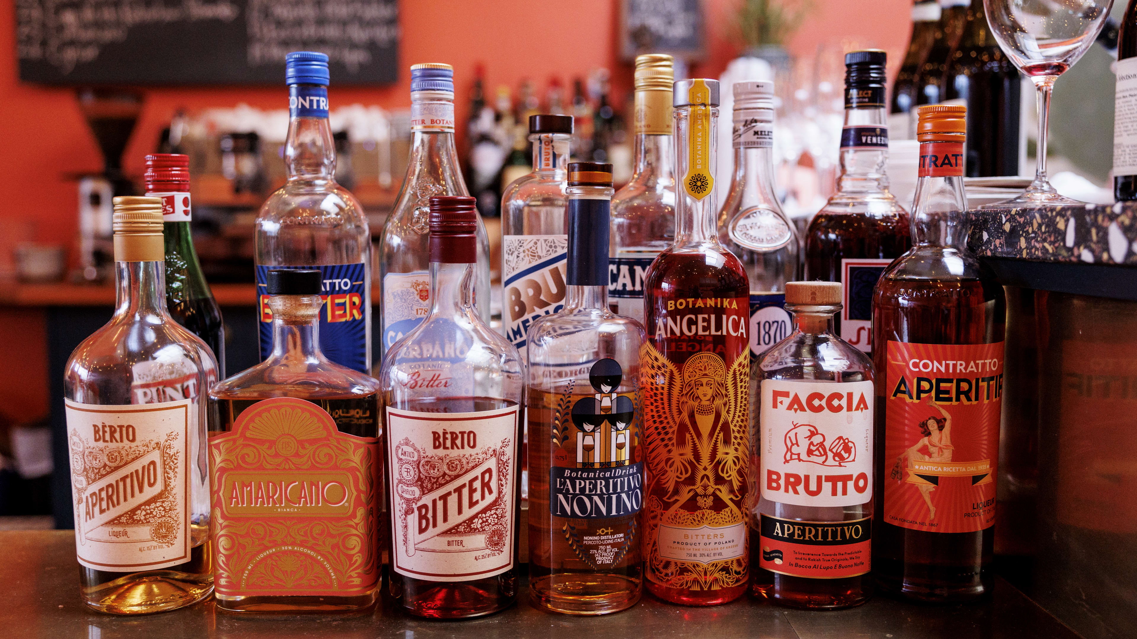 Bottles of aperitifs lined up on a bar.