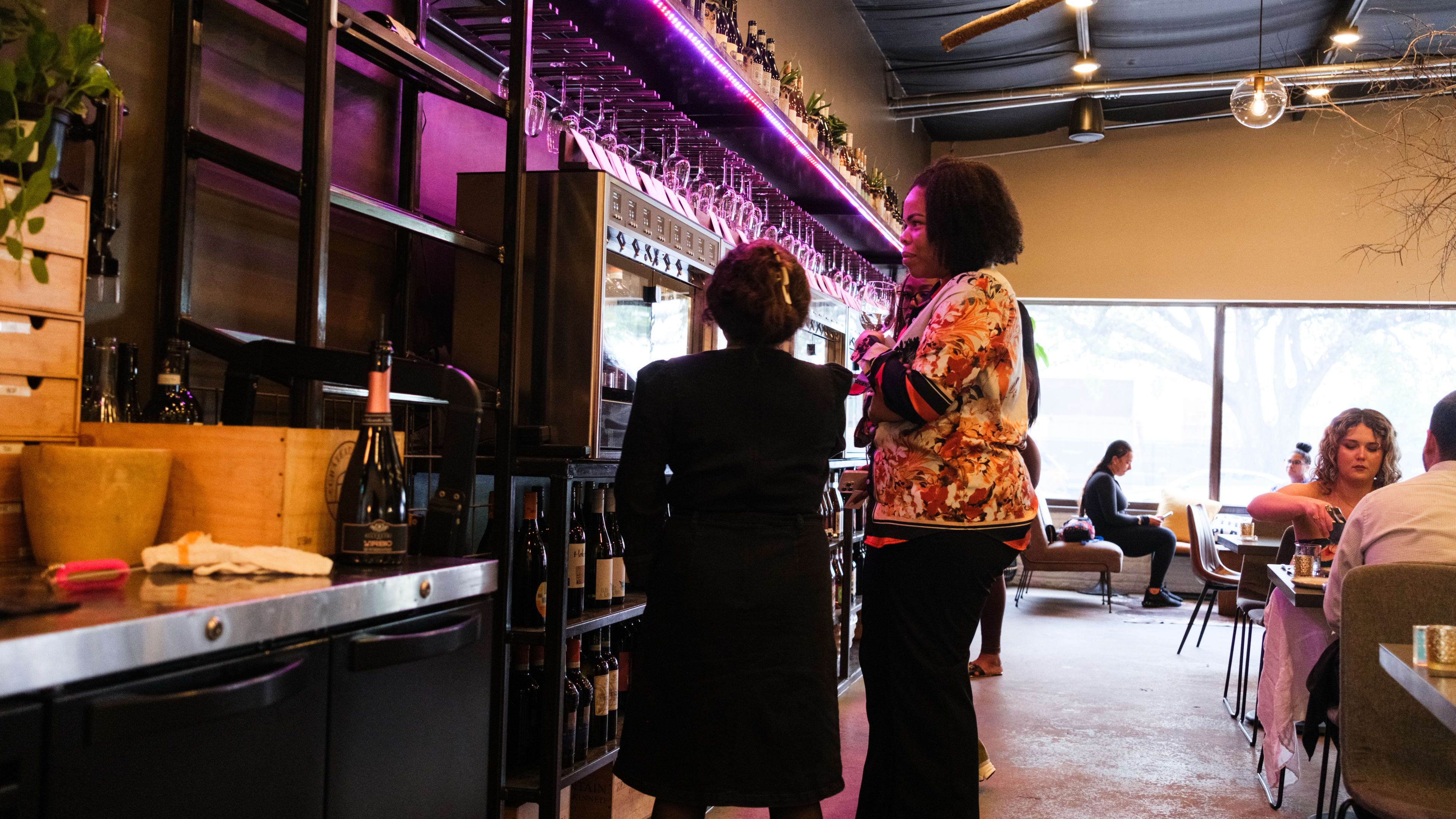 A person speaks with a sommelier at Roots Wine Bar.