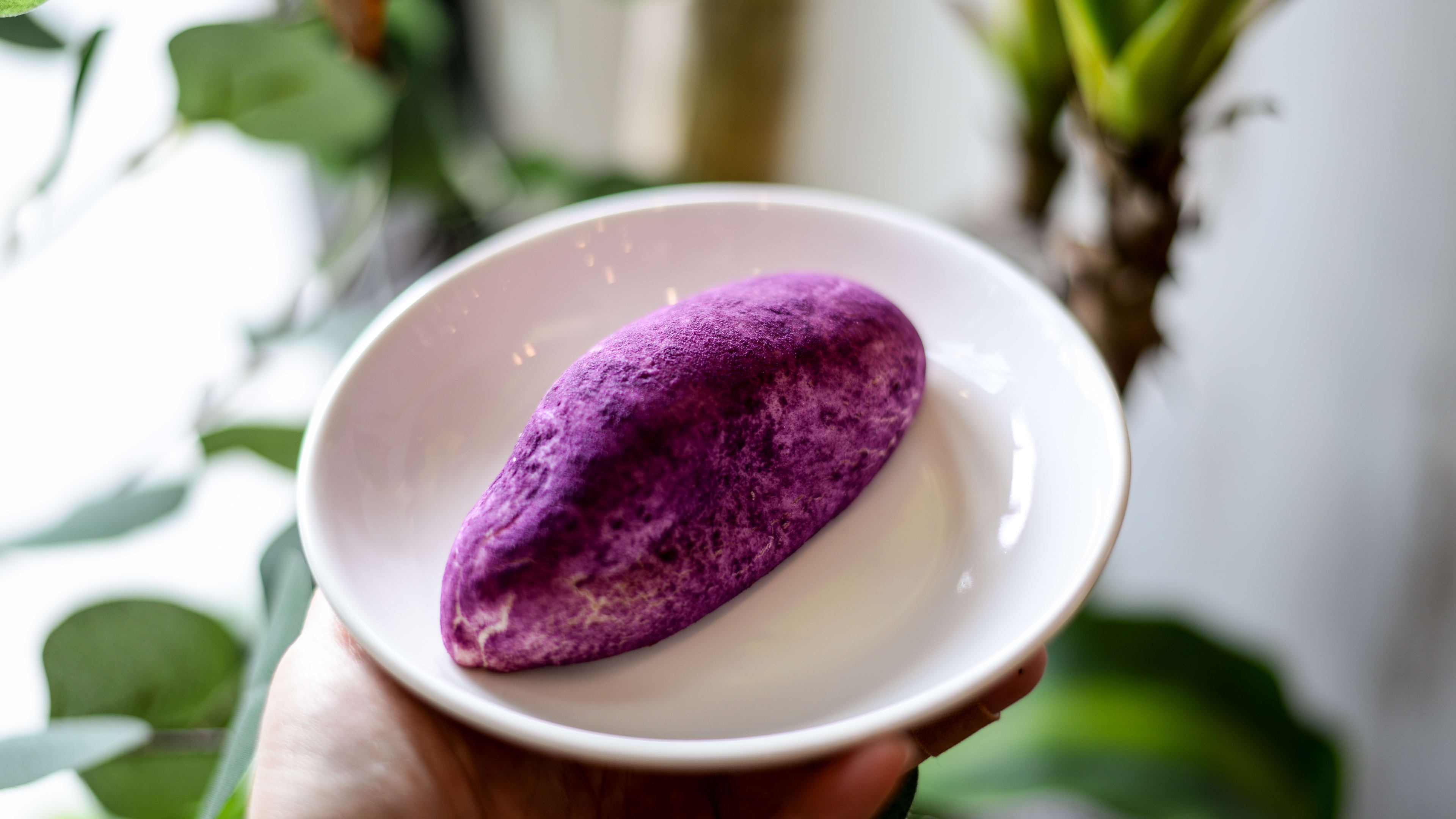 oval shaped ube bun on a ceramic plate