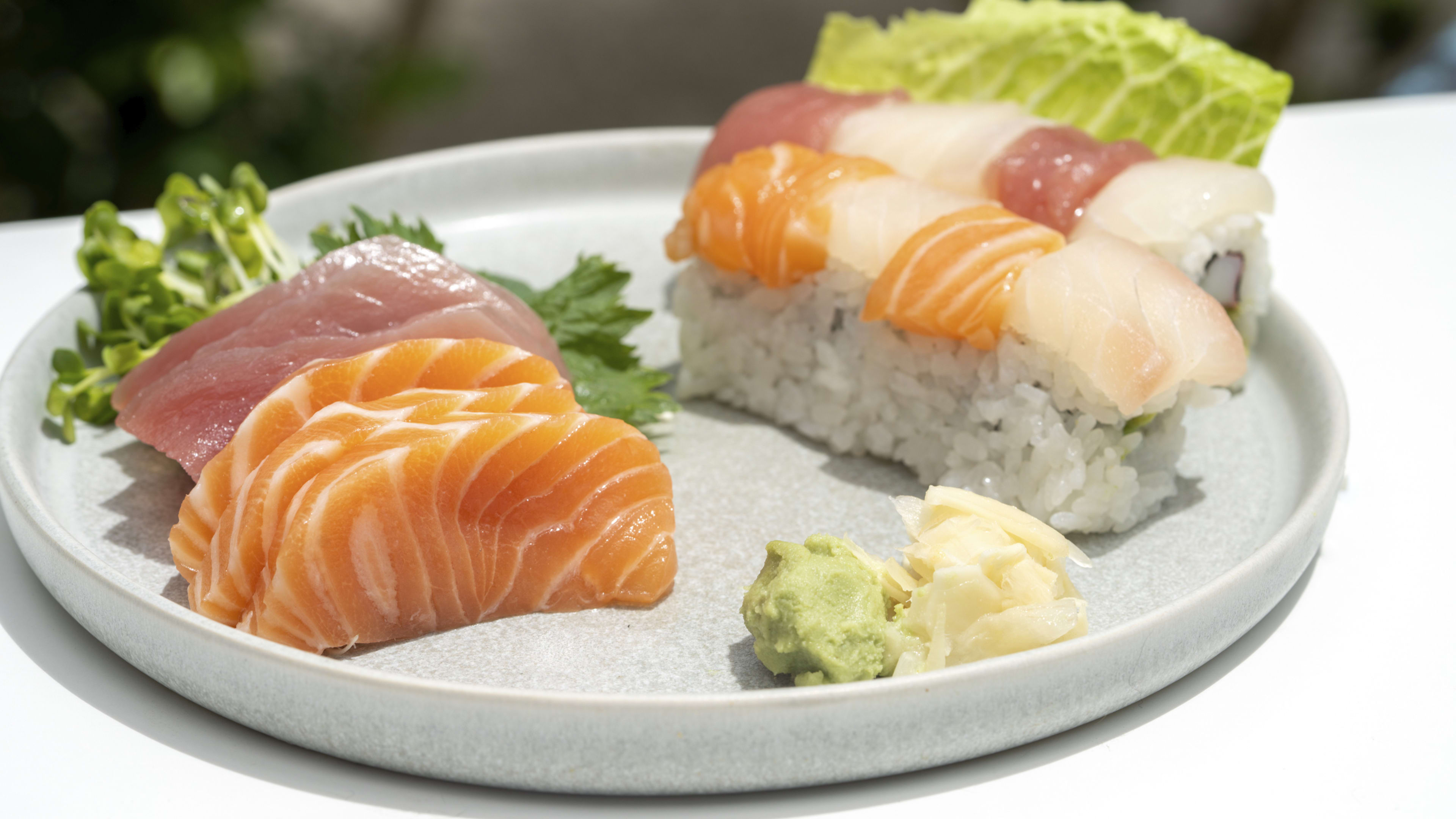Salmon and tuna sashimi and sushi rolls on a plate