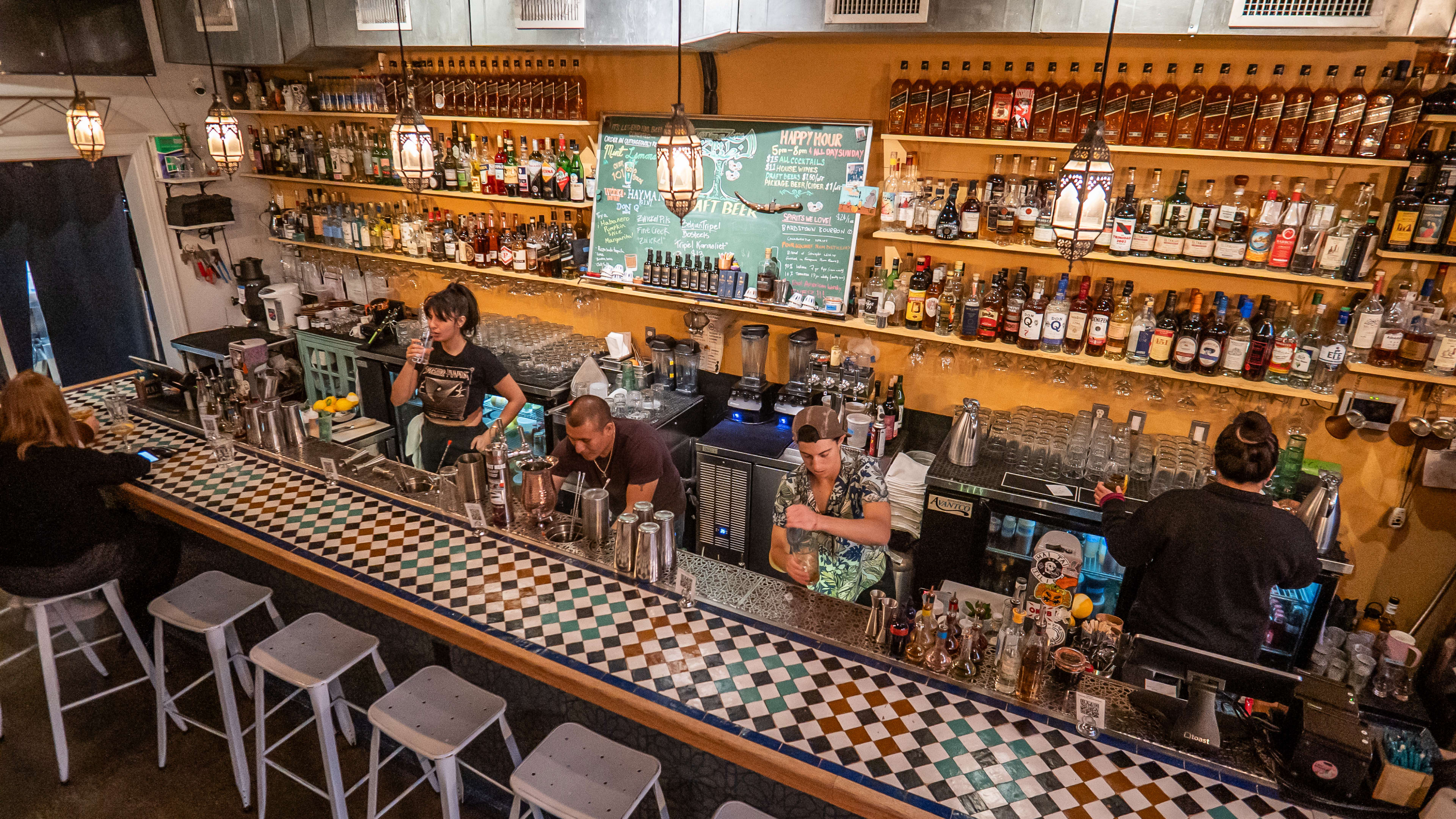 Aerial shot of mosaic bar with bartenders preparing drinks.