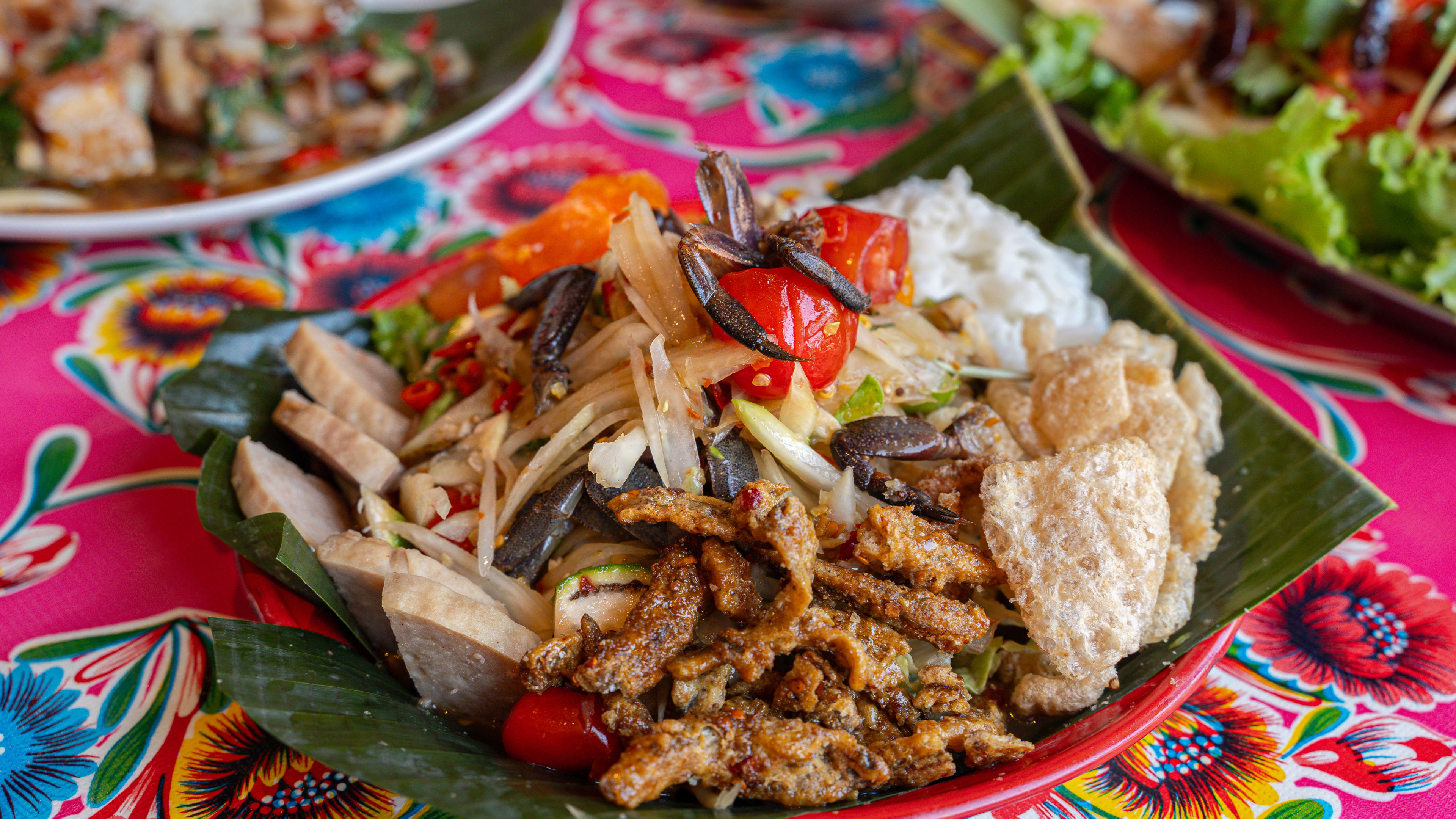 A plate of tum tuk tuk on a colorful floral tablecloth.