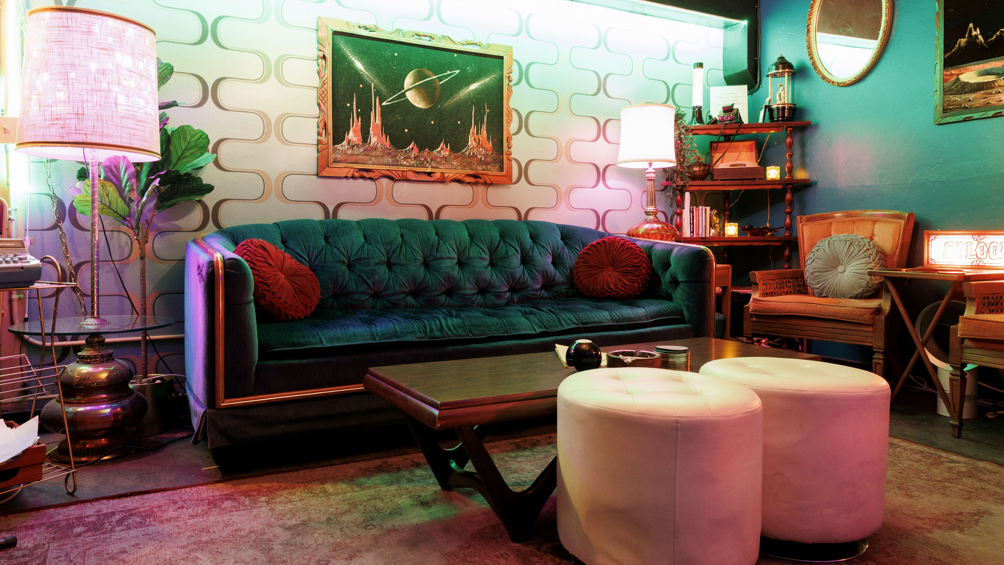 Kitschy bar interior with velvet couches and mismatched furniture.