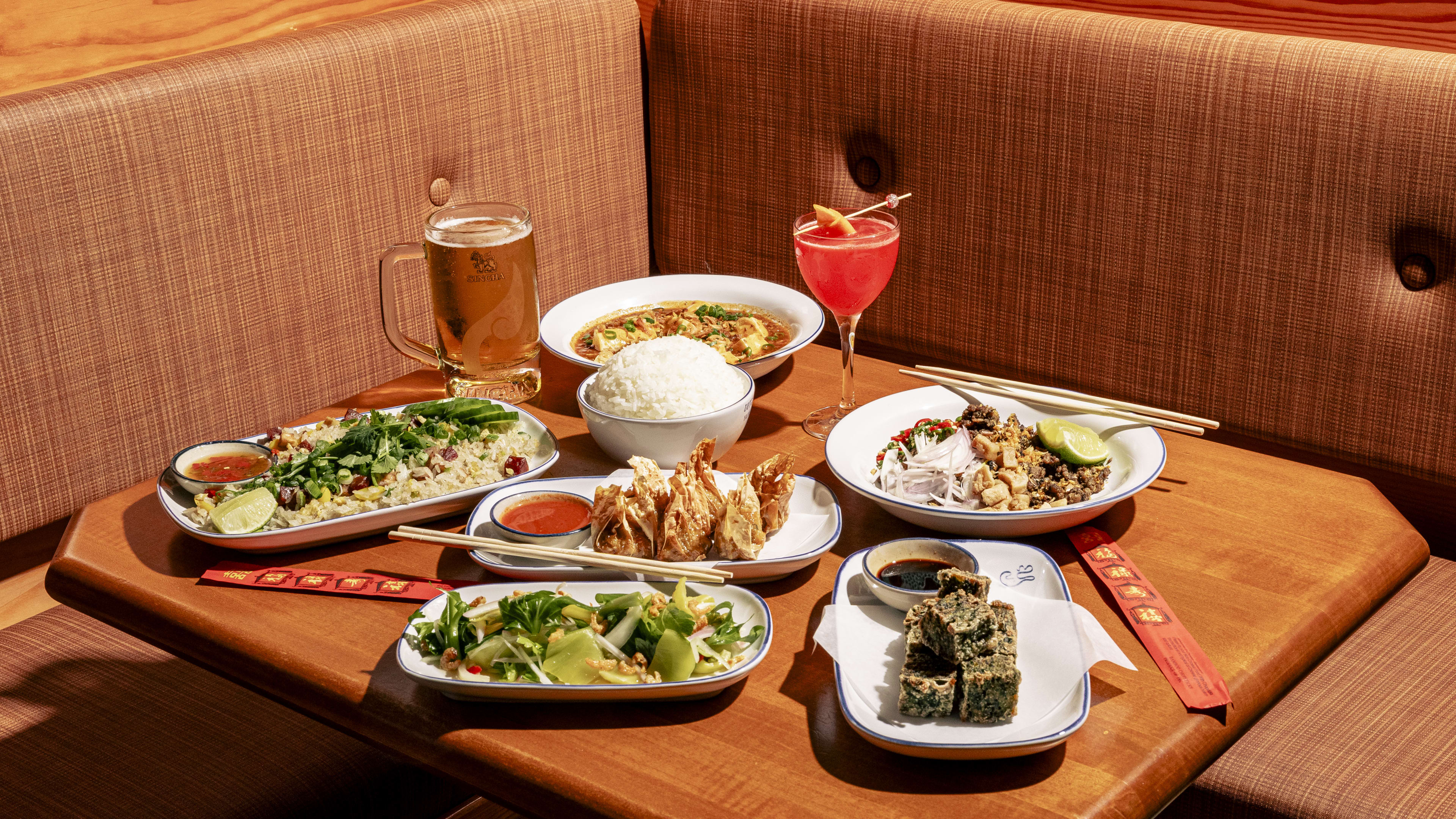 Spread of dishes and cocktails on wooden table at Yaowarat