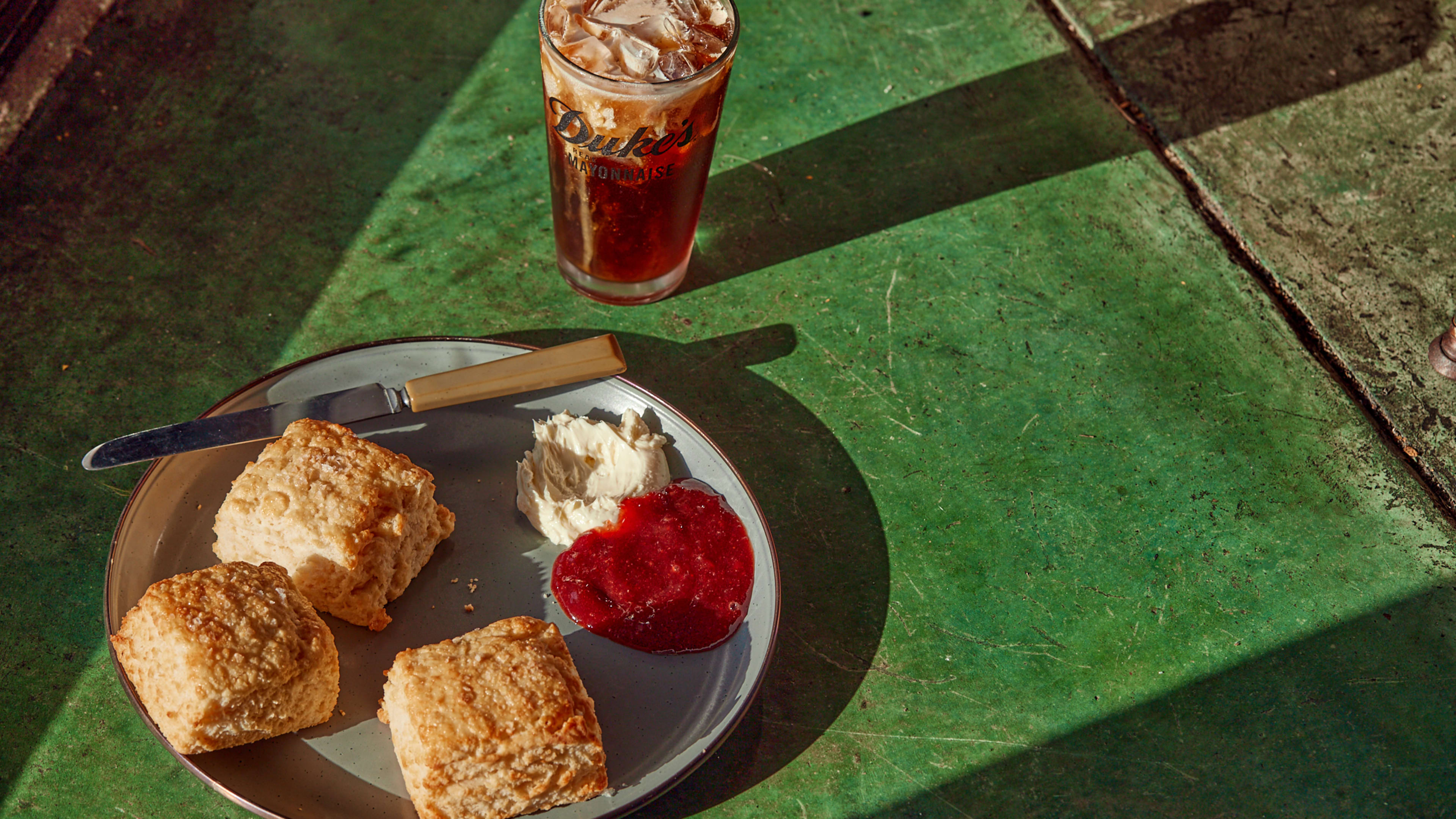 Biscuits with cream and jam on green table at Molly's Rise & Shine