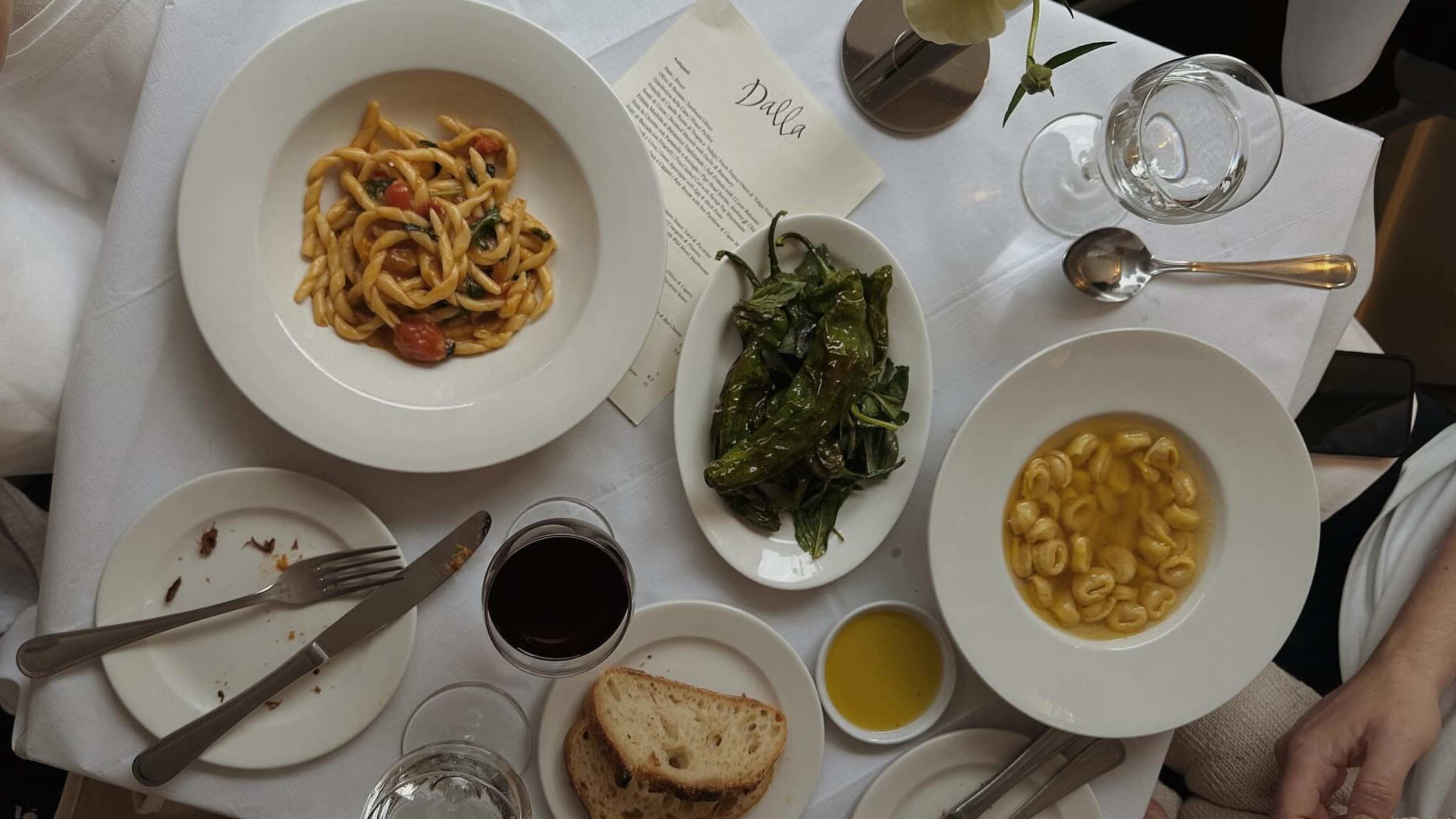 A table of brodo, pasta, charred peppers, and bread from Dalla in Hackney.