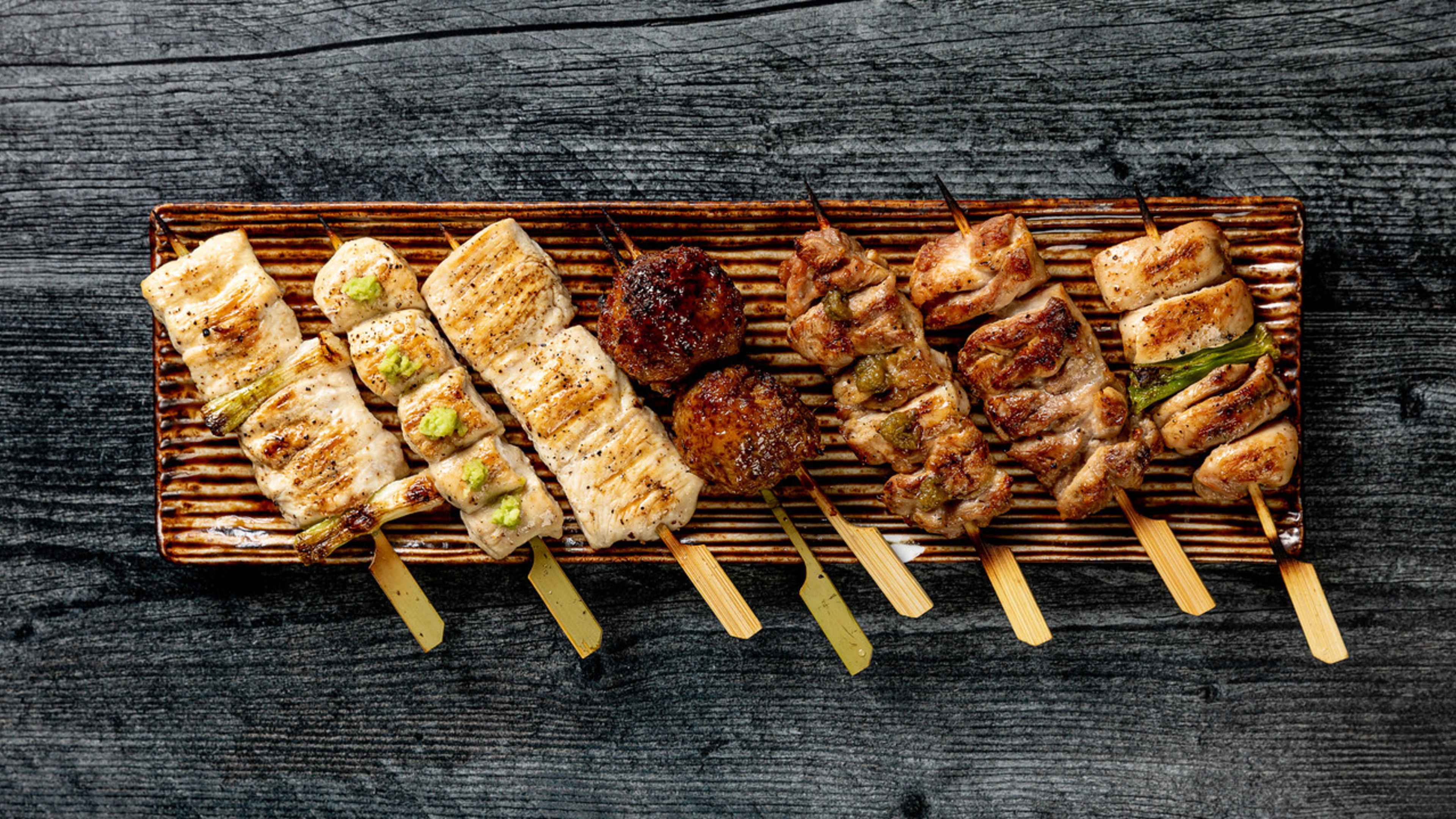 a plate full of grilled Japanese skewers