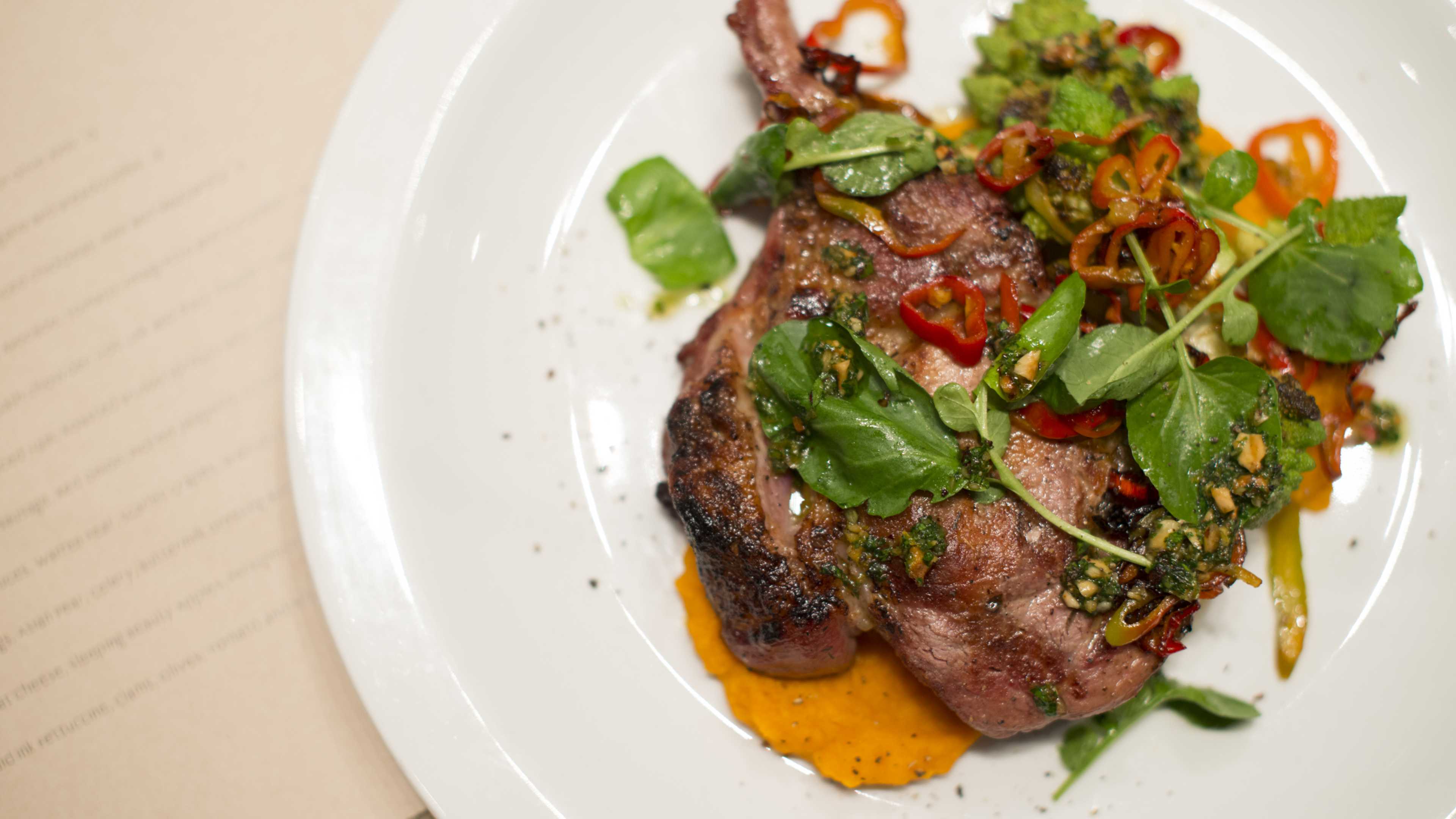 pork chop with greens and chilis on plate