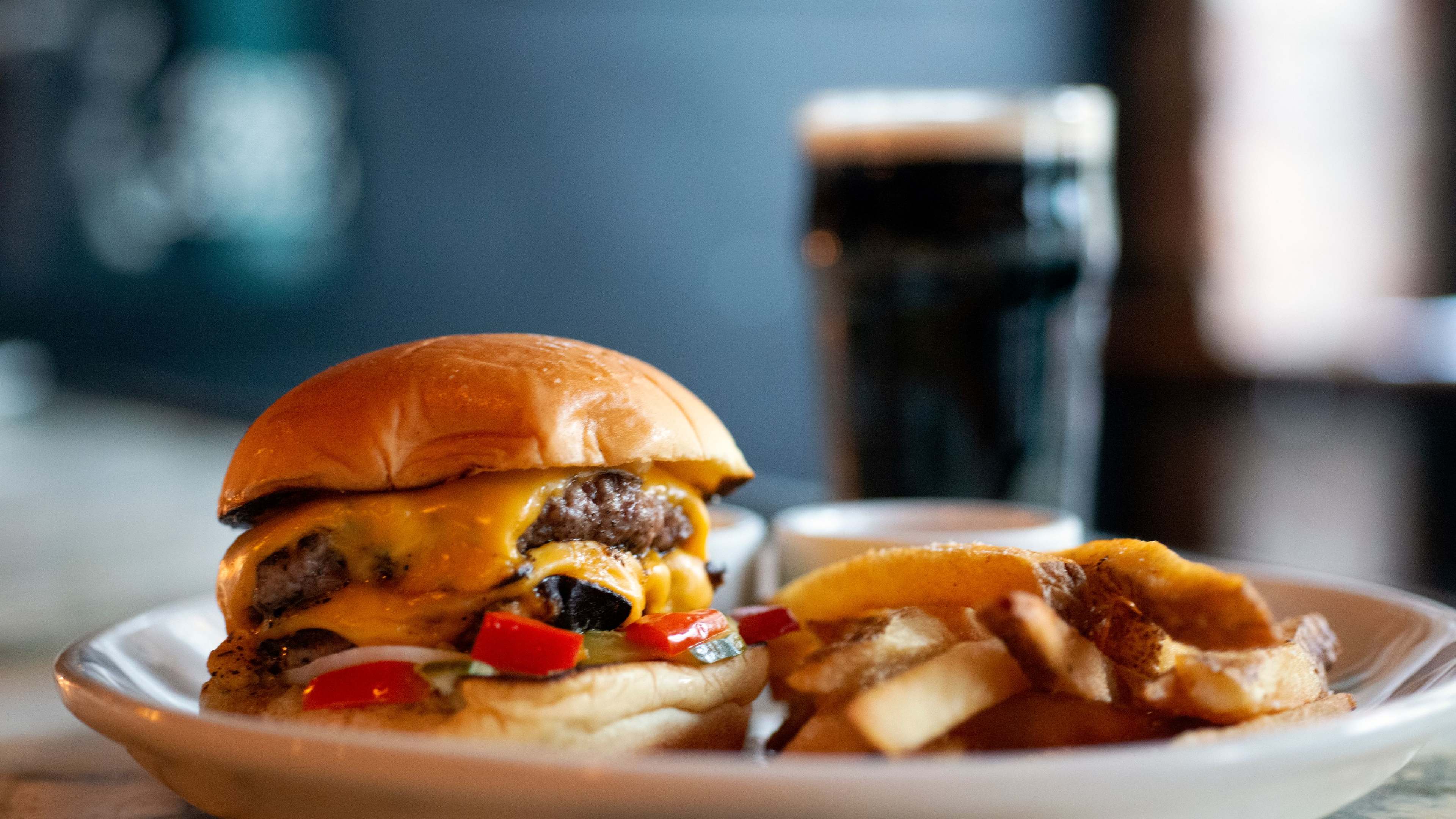 A double cheeseburger on a plate with fries.