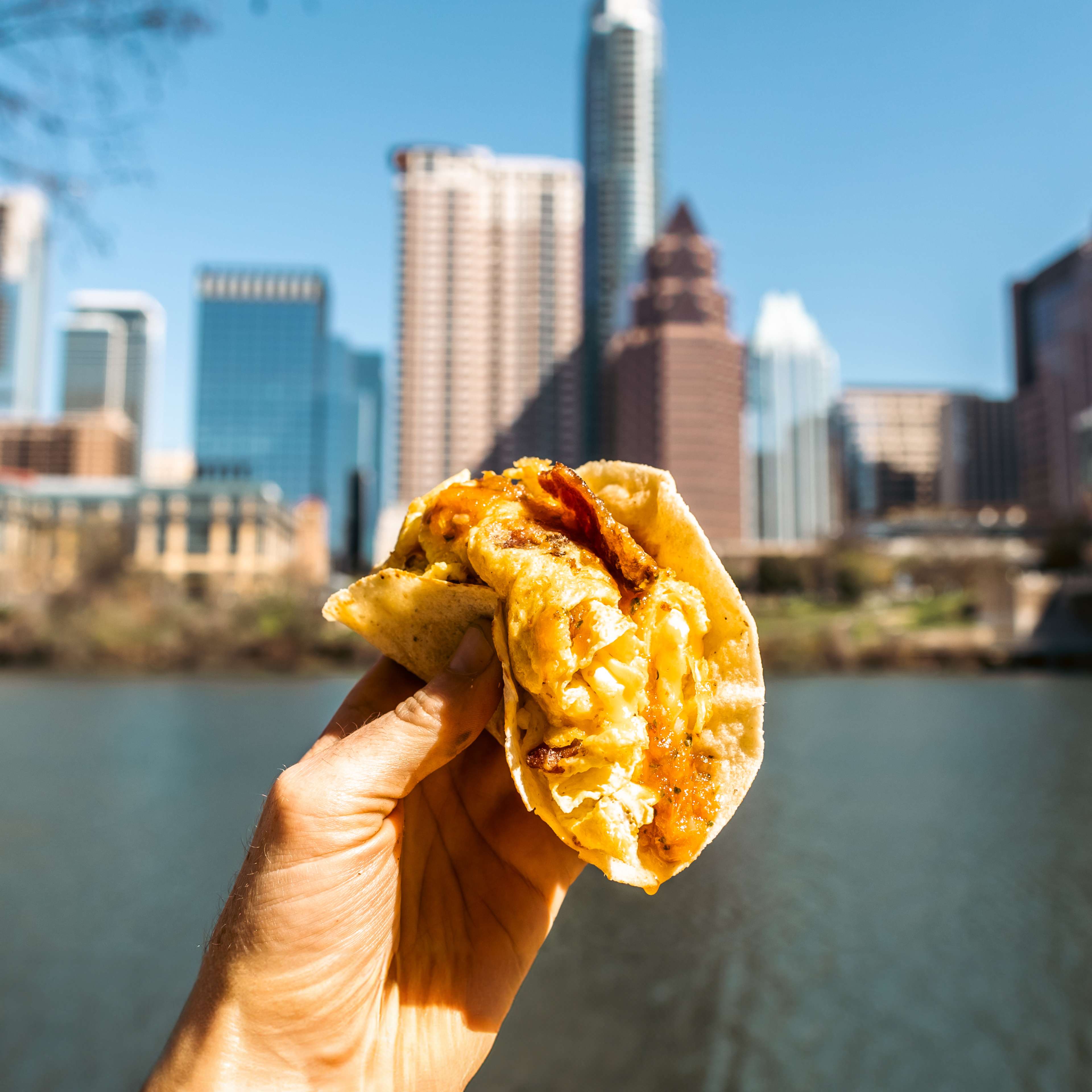 A breakfast taco held up against the skyline