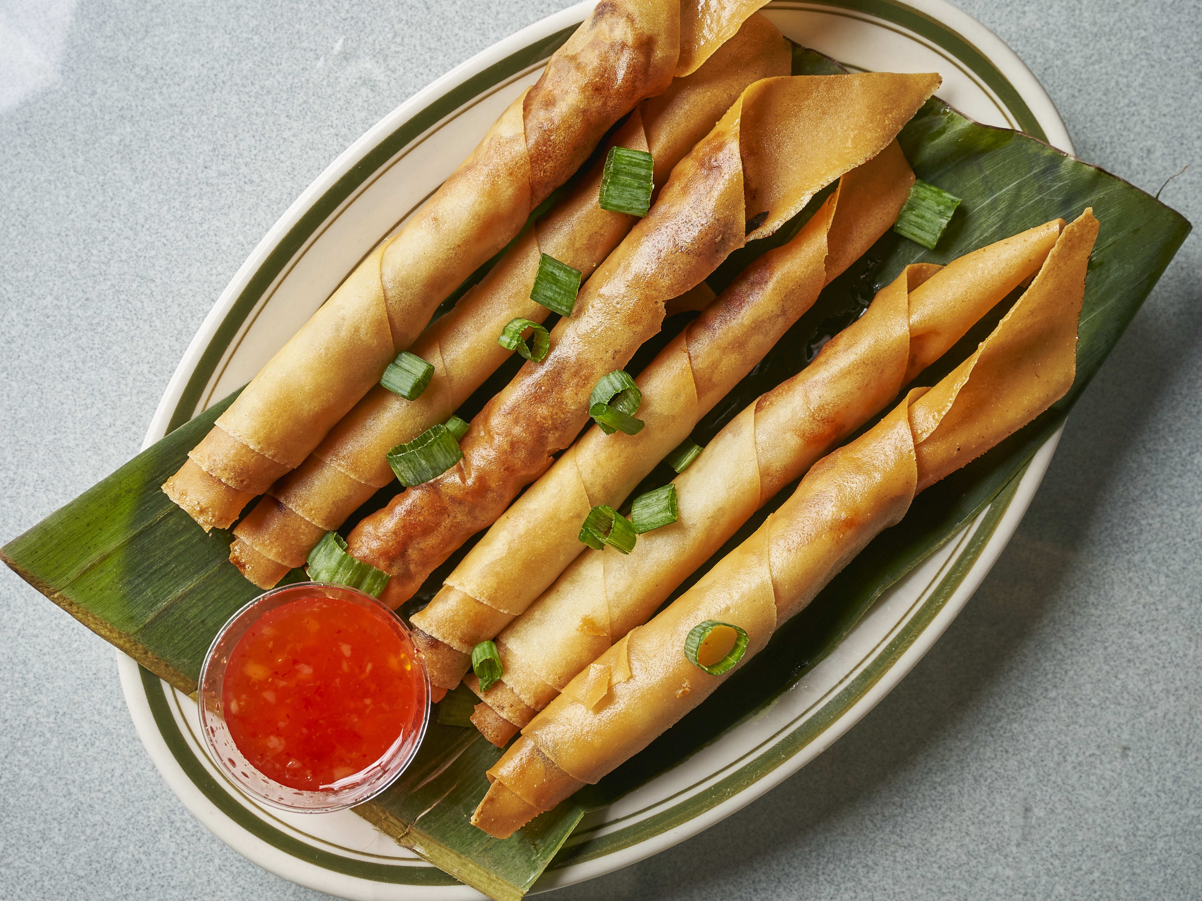 Lumpia from Papa's Kitchen on a plate with dipping sauce