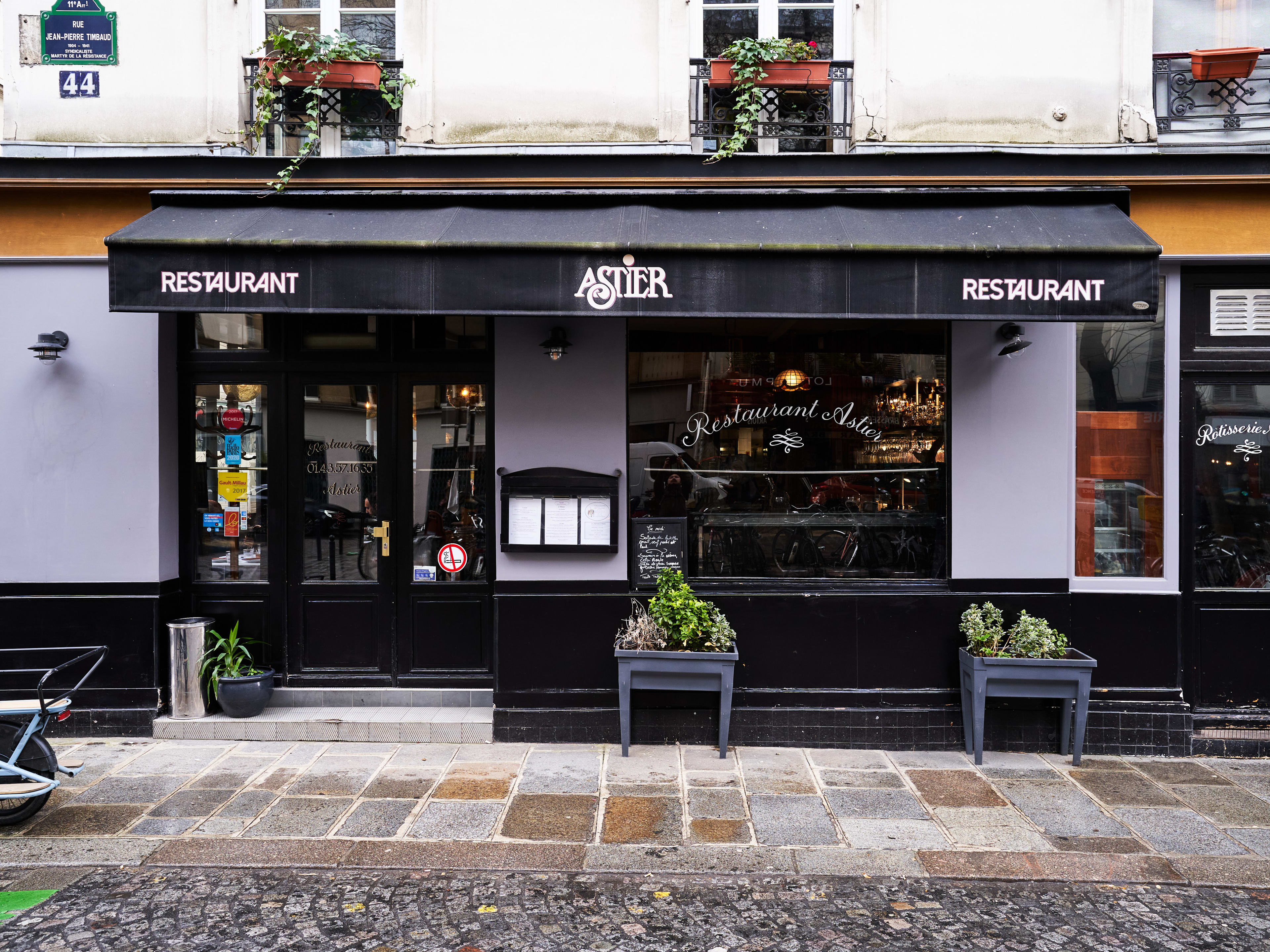 Facade of Restaurant Astier with black awning.