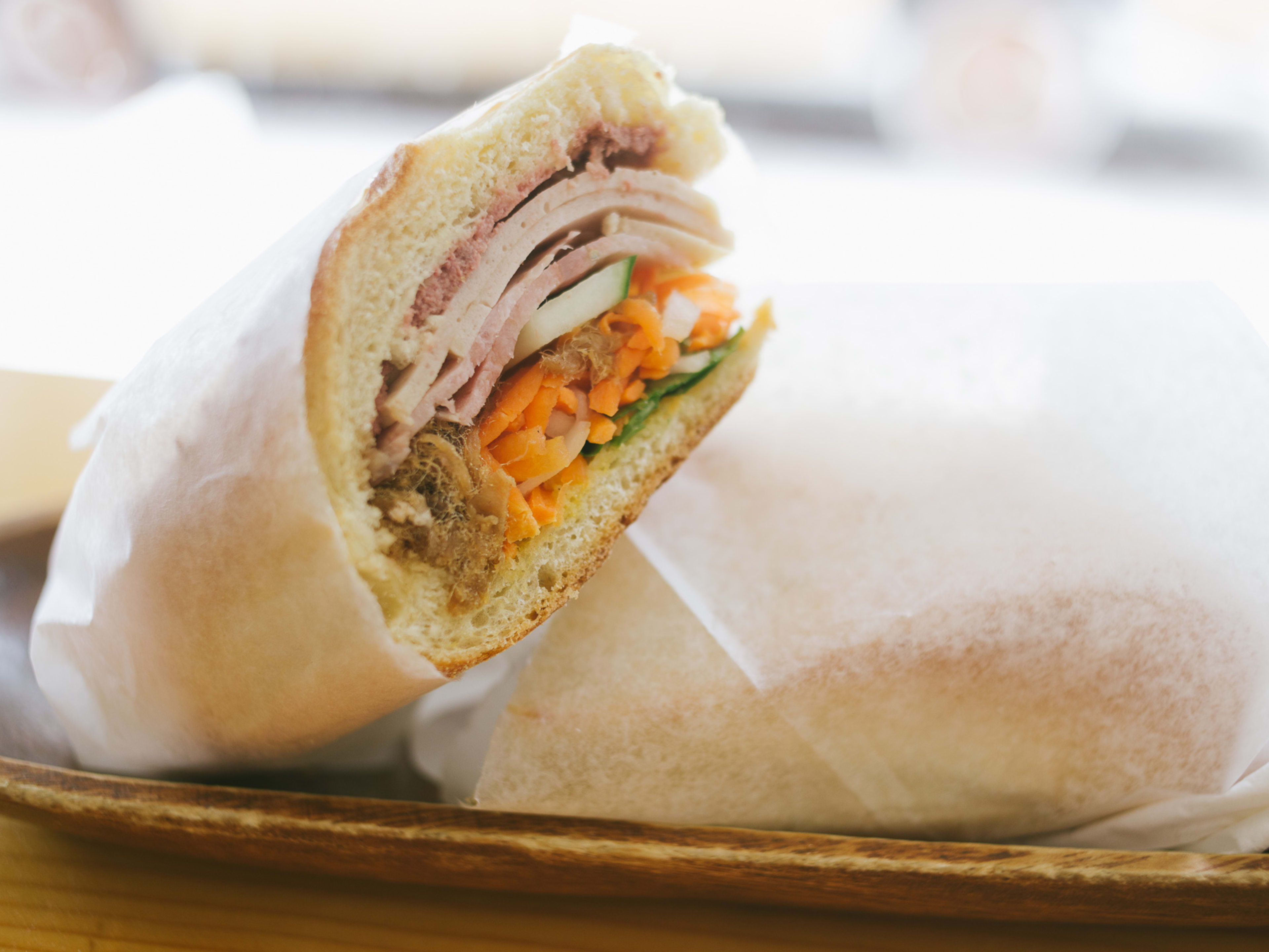 Banh Mi sandwich cut in half and wrapped in wax paper from Banh Mi Zon