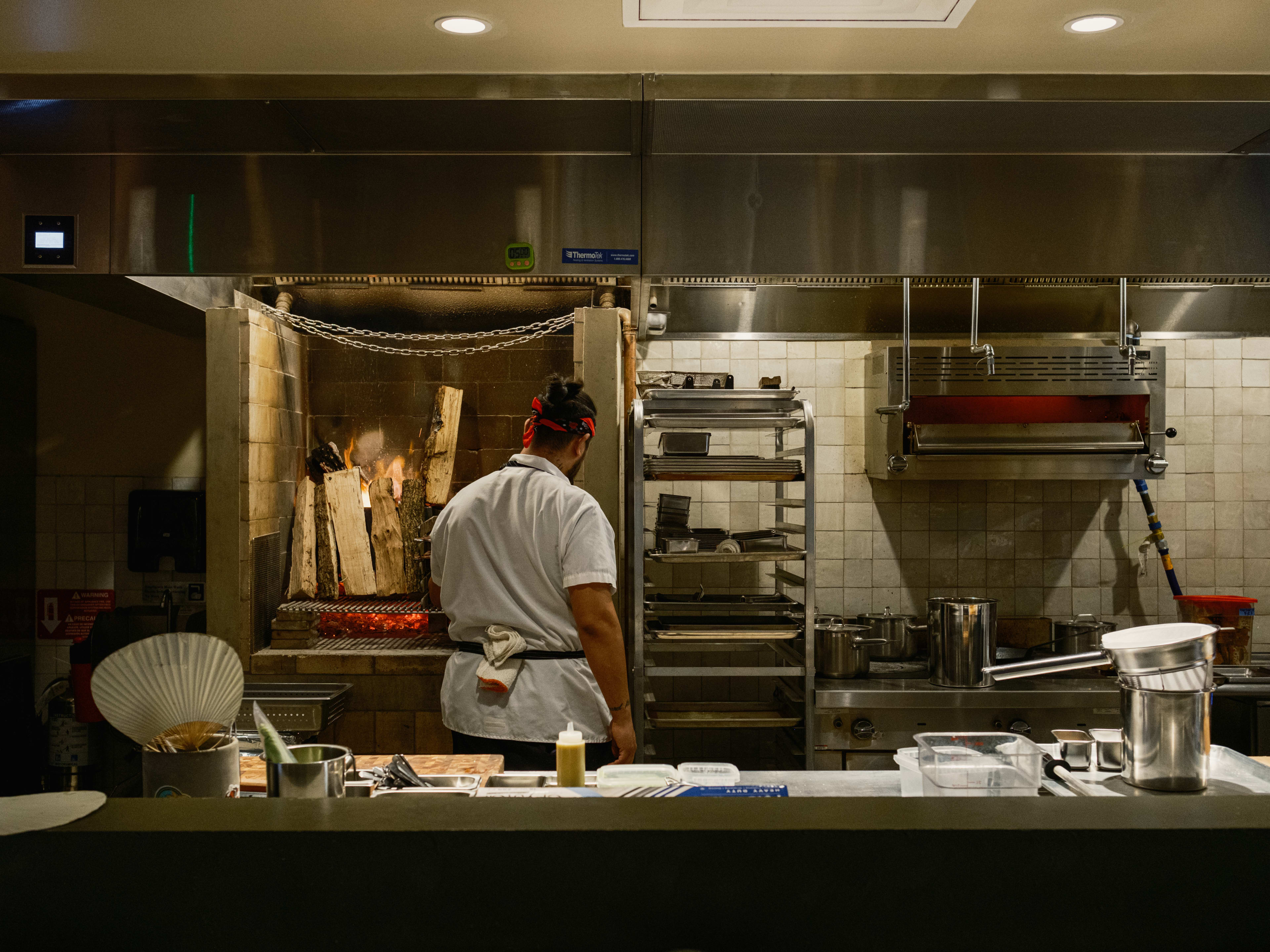 open kitchen at Baso with a chef cooking in front of an open flame