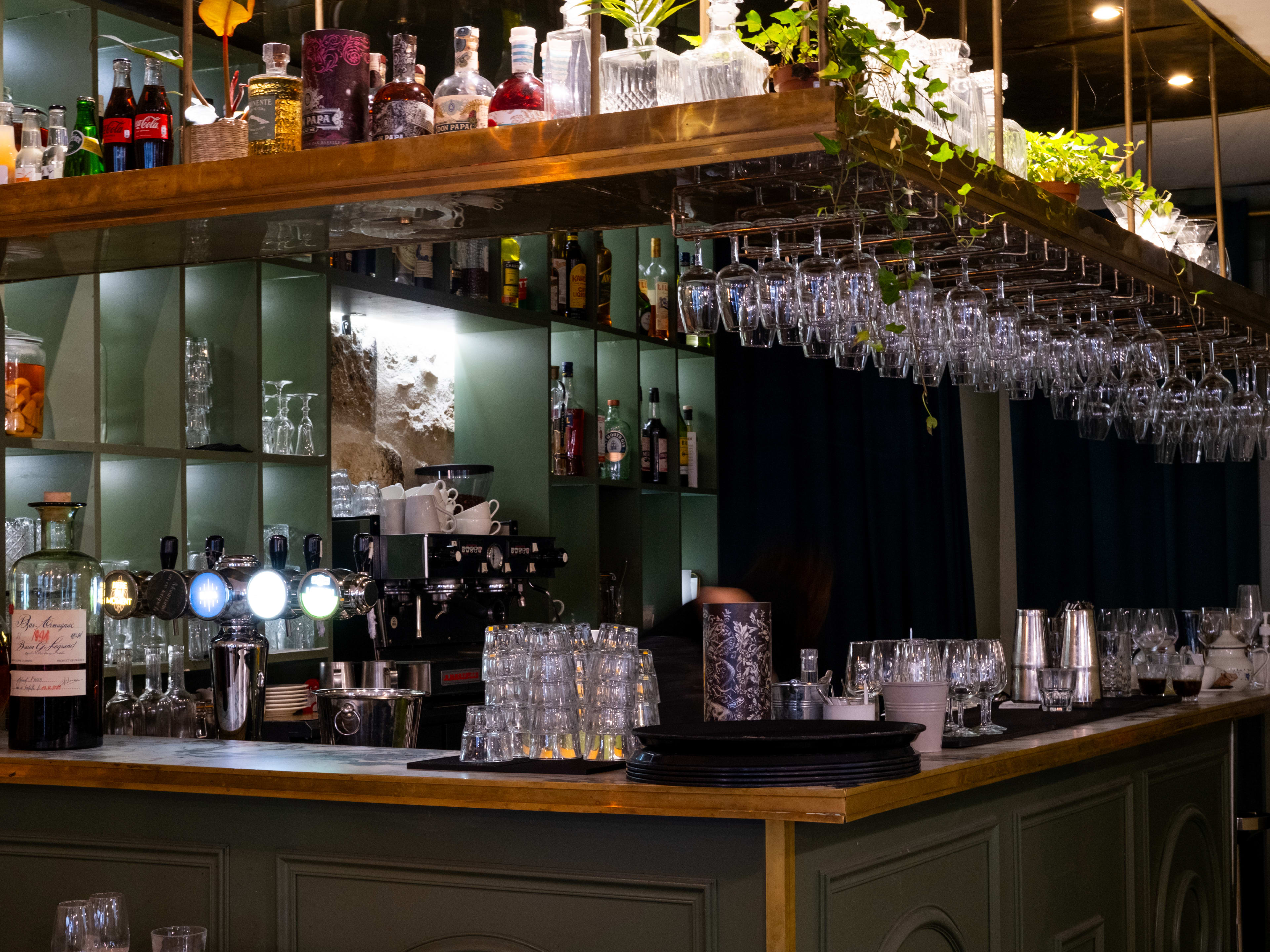 Bar area with racks of wine glasses at Cafe De Luce