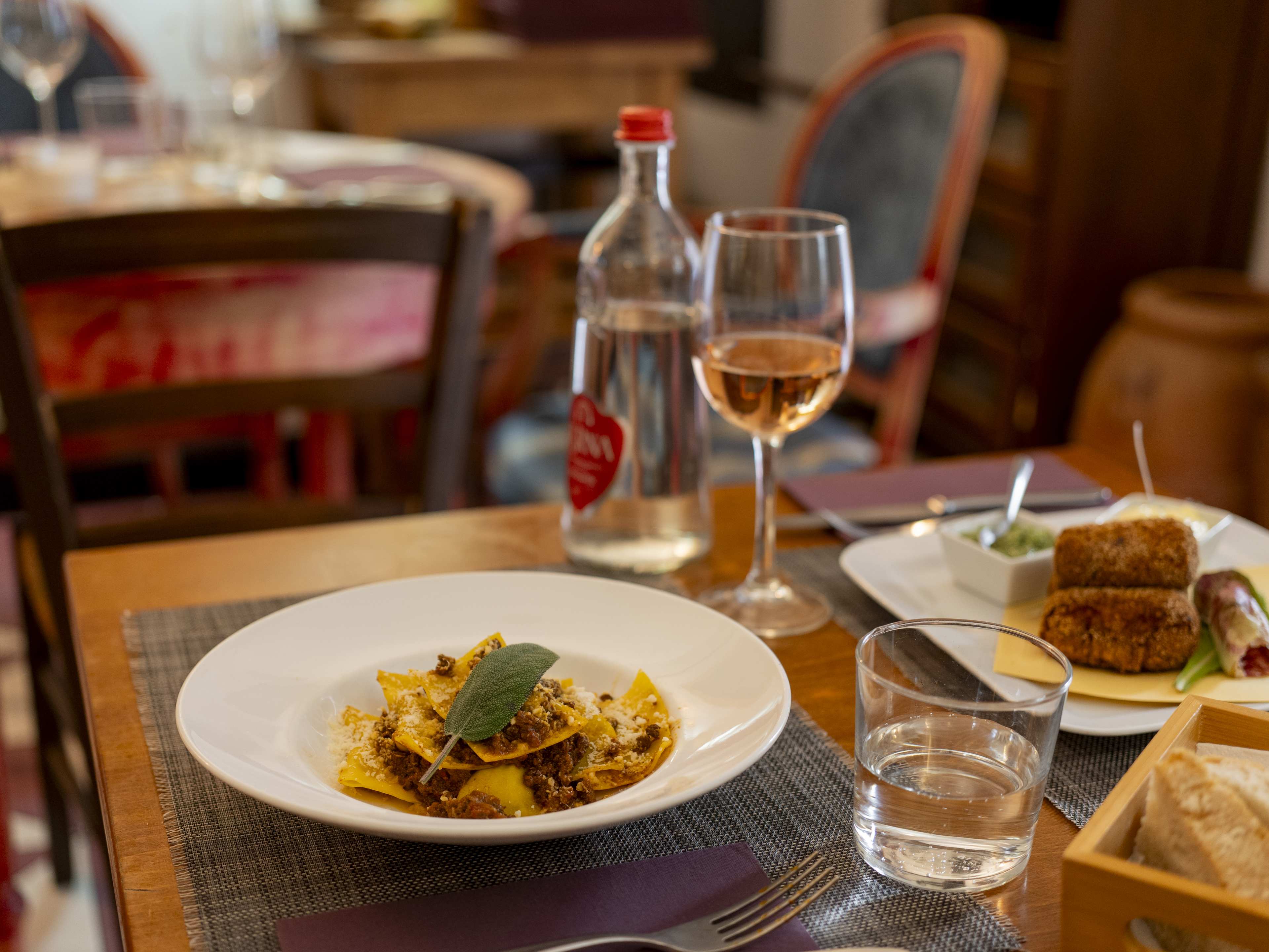 Spread of Italian dishes and rosé wine at Club Culinario Toscano Osvaldo