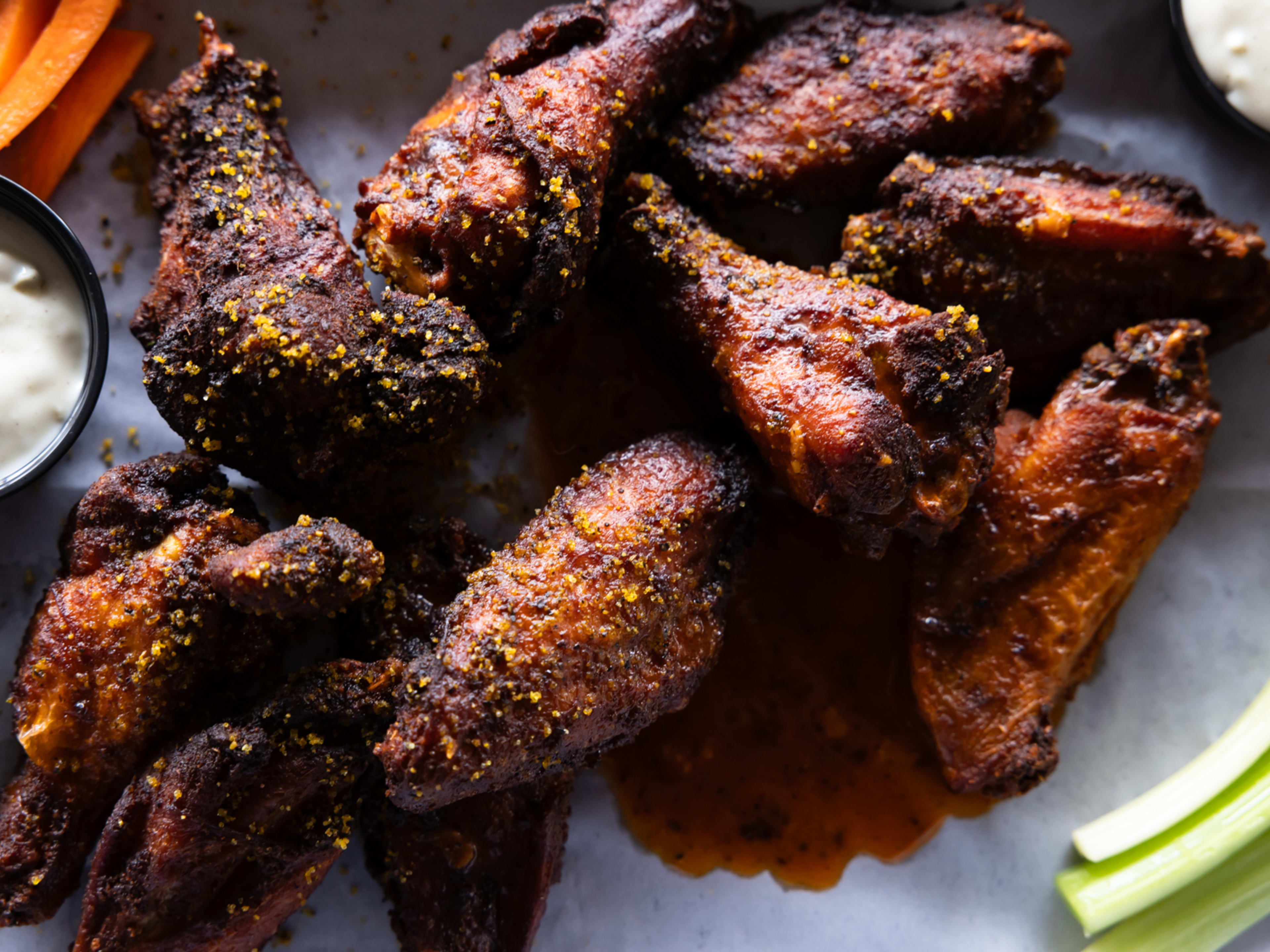 Chicken wings with seasoning, dip and celery.