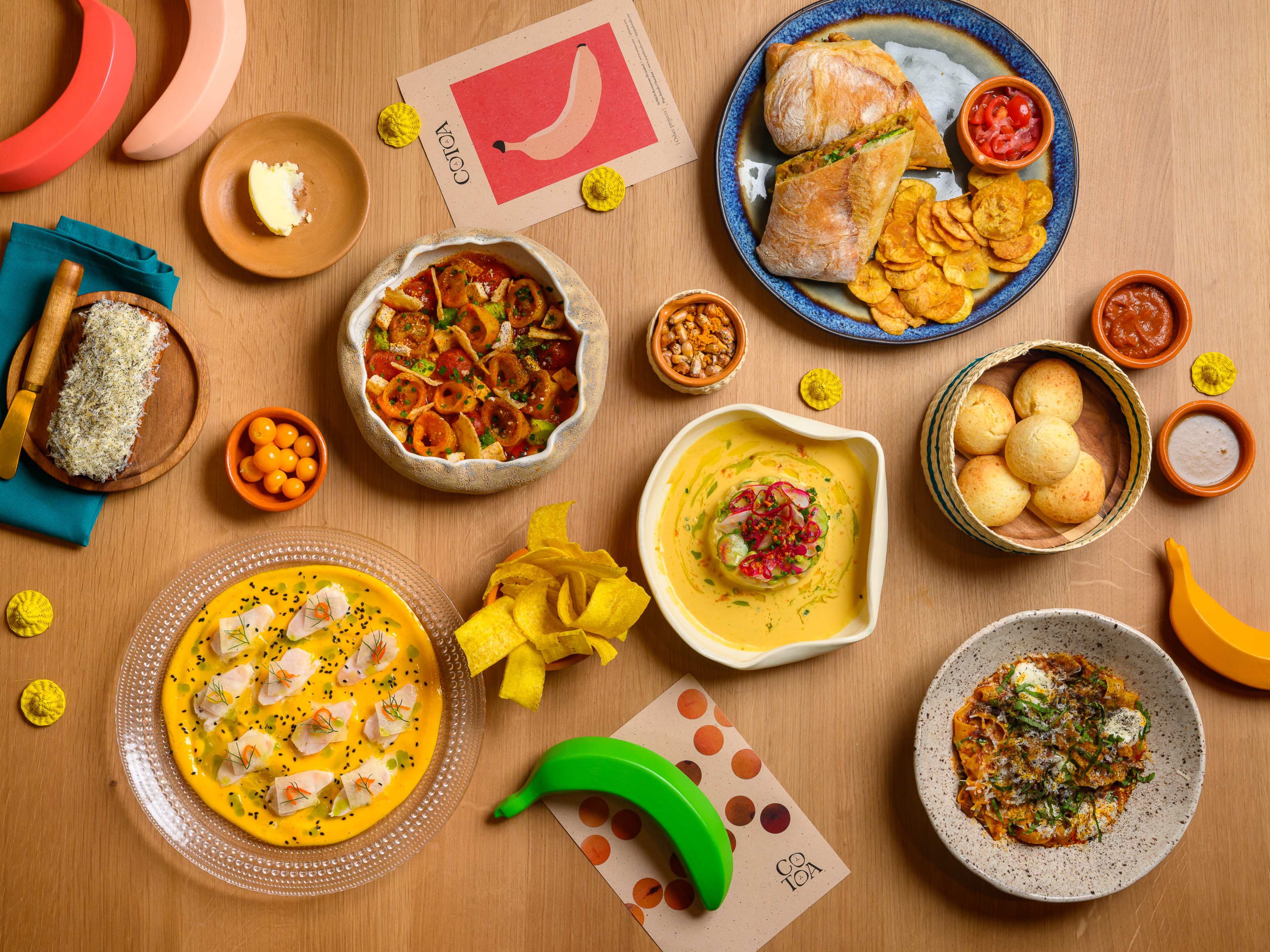 spread of pastas, ceviche, crudo and other ecuadorian dishes with colorful decorative bananas