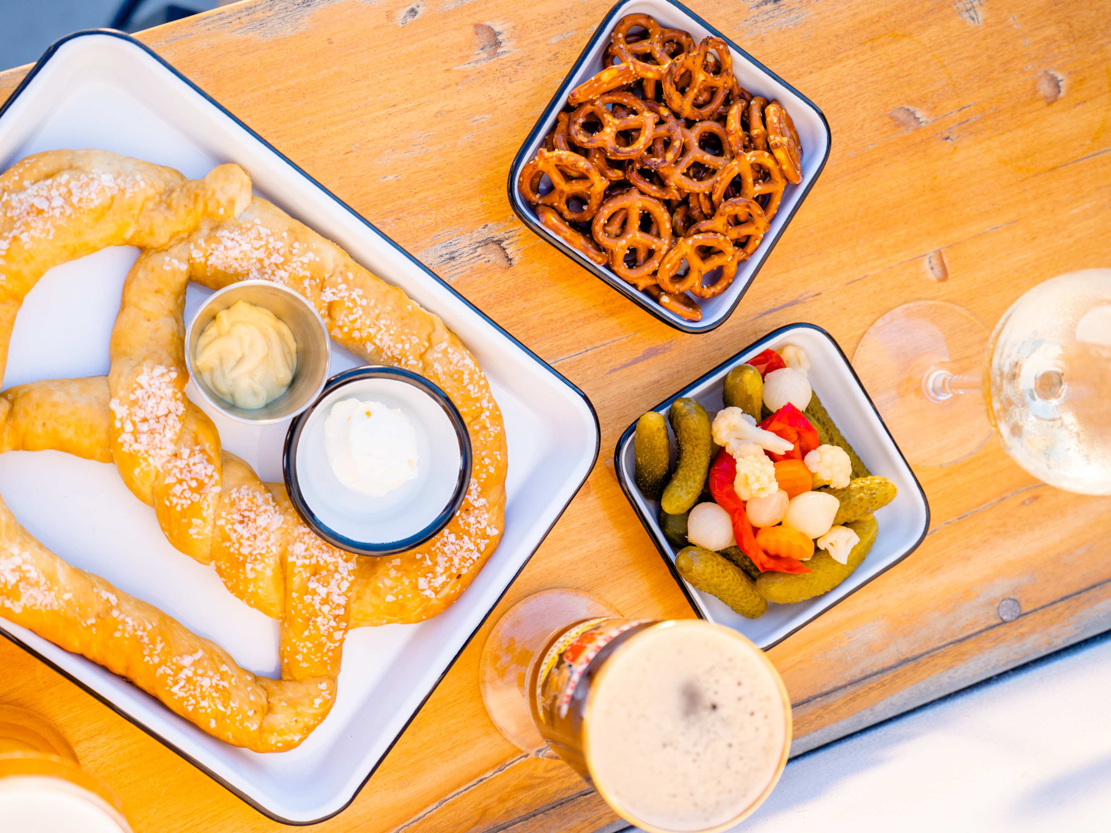 Spread of bar snacks including soft pretzel and dips at Bajavaria