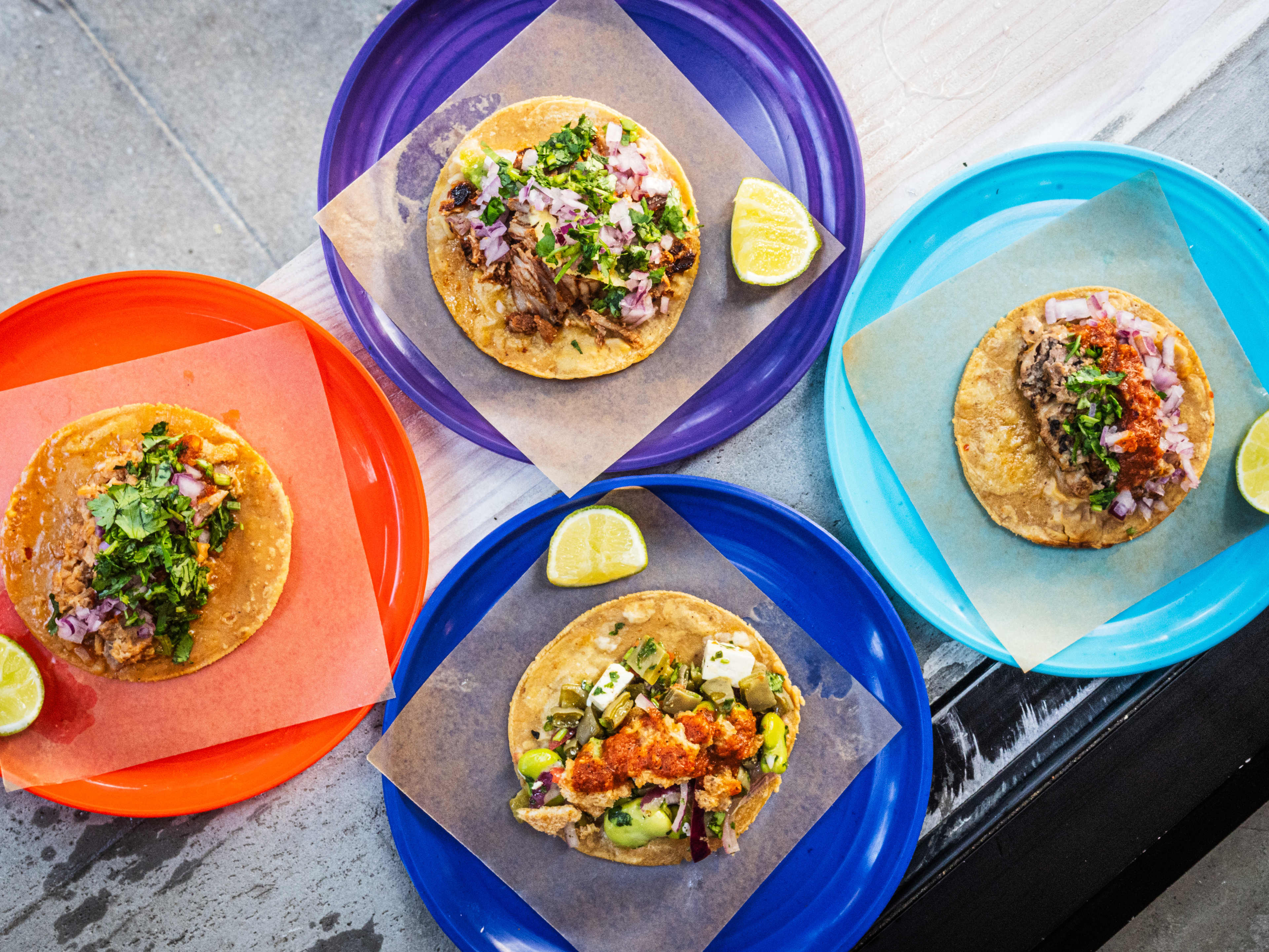 A spread of four different tacos on separate plates from Taqueria Ramirez.