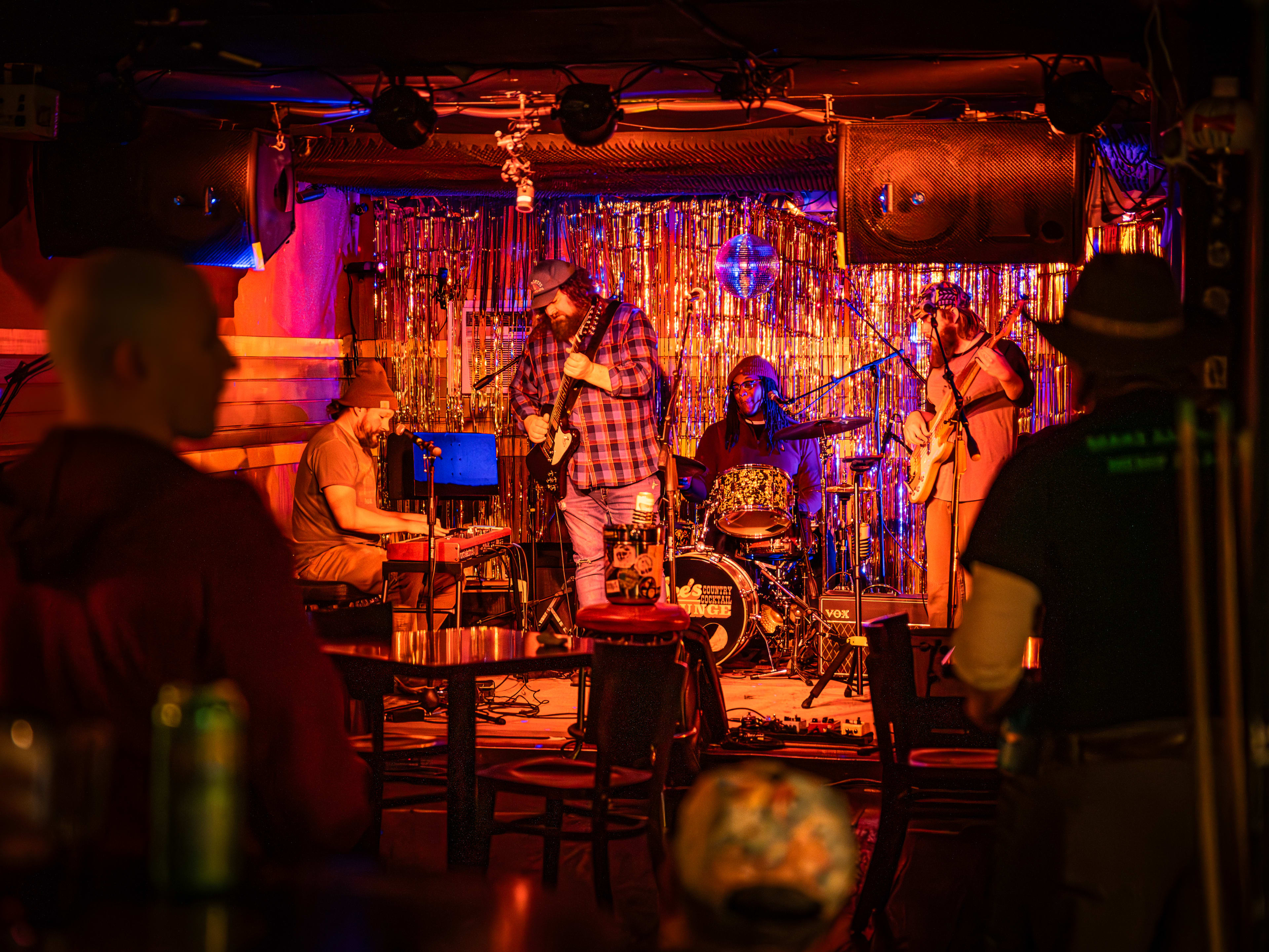 Bluegrass band playing live set on dimly-lit stage at Dee's Country Cocktail Lounge