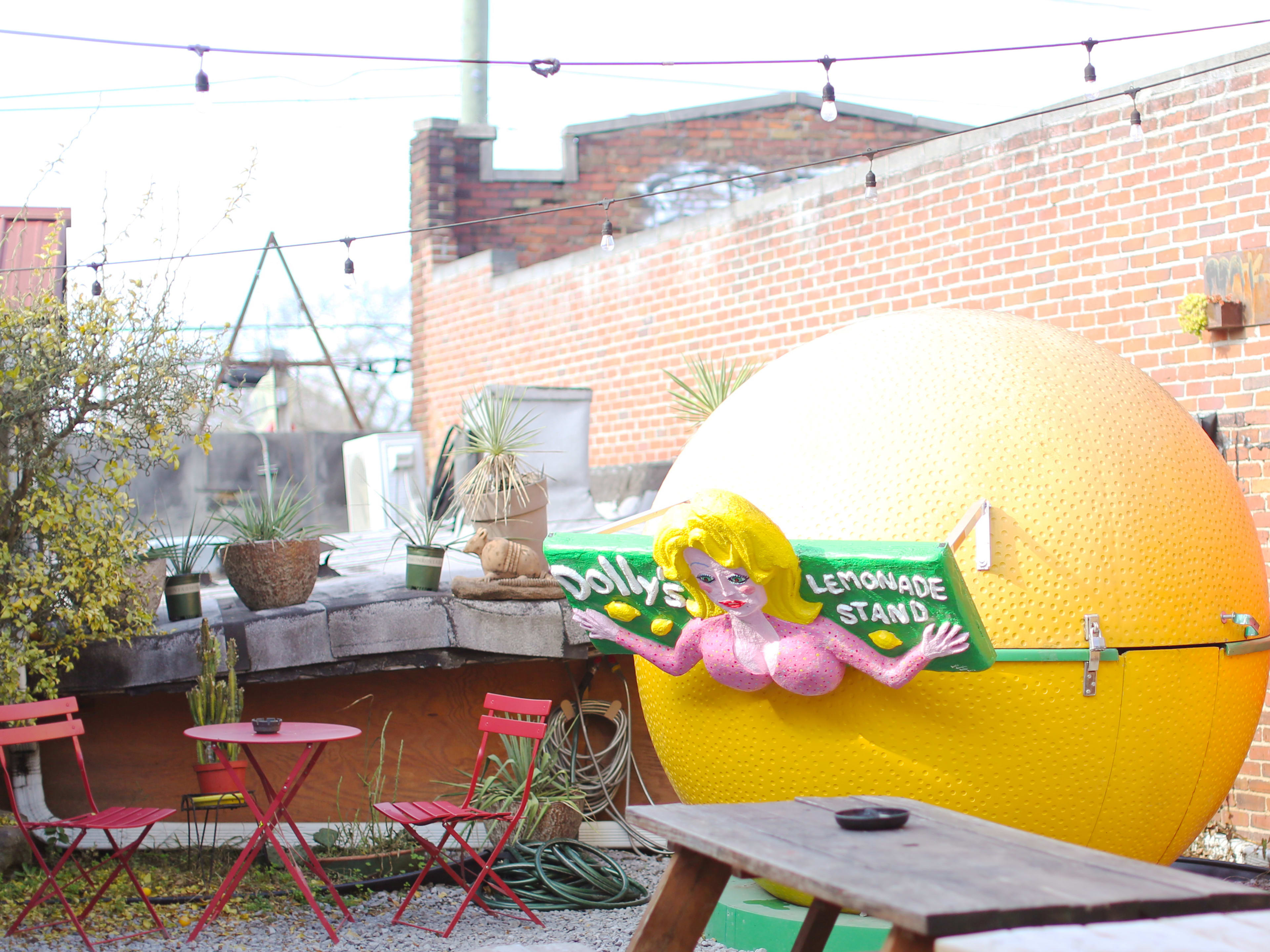 Exterior patio space with a Dolly Parton-themed lemonade stand at Dino's Bar & Grill