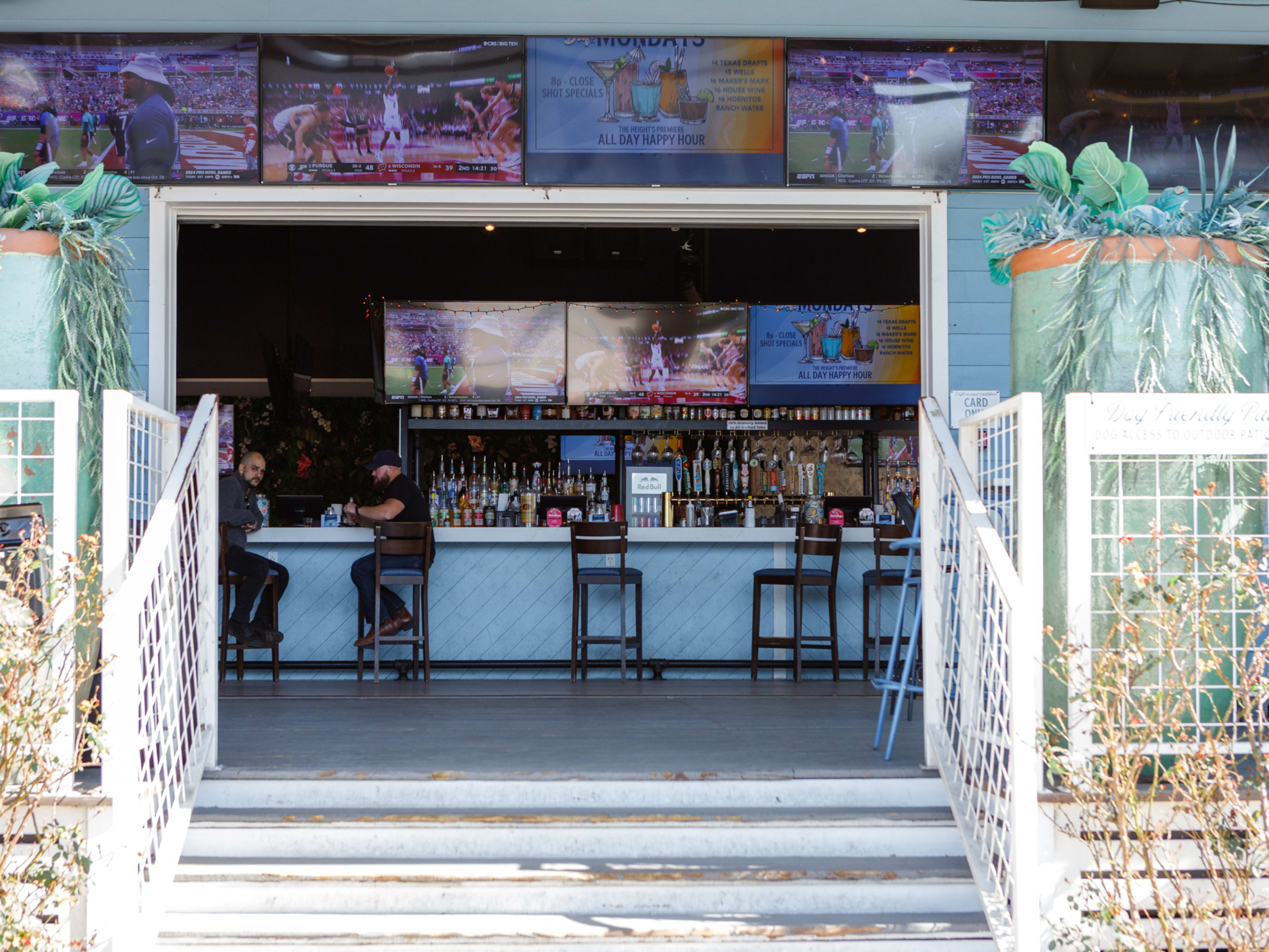 sports bar exterior stairs leading into light blue bar top with wall mounted TVs