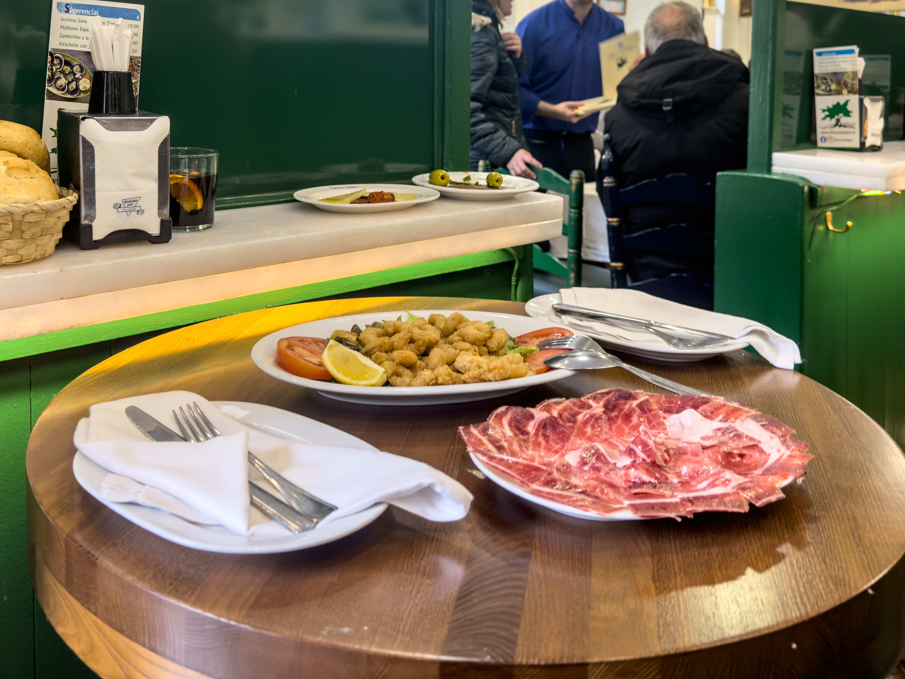 Charcuterie plate and fried shrimp on wooden table at El Rincón de Jaen I