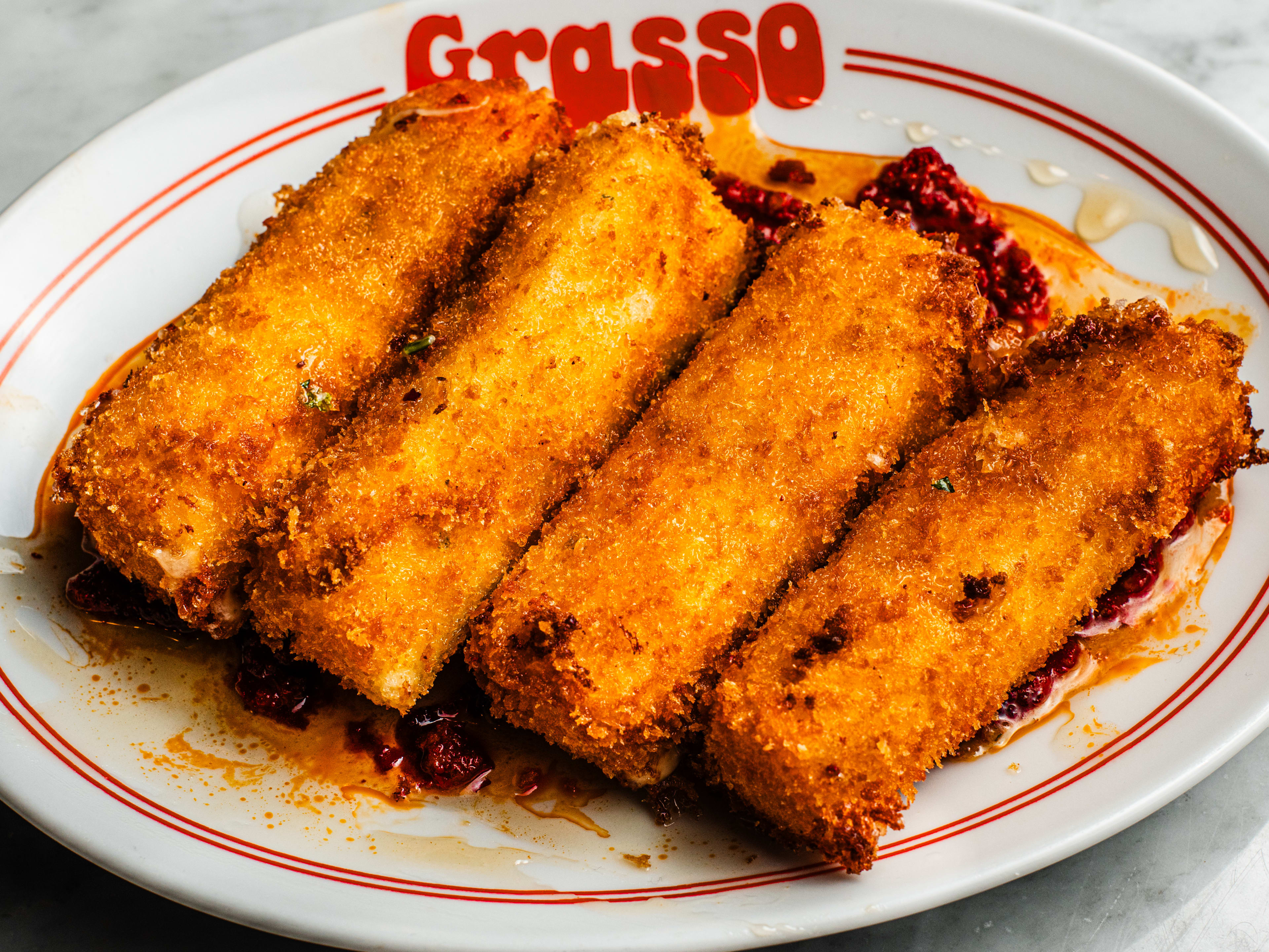 A plate of four golden mozzarella sticks.