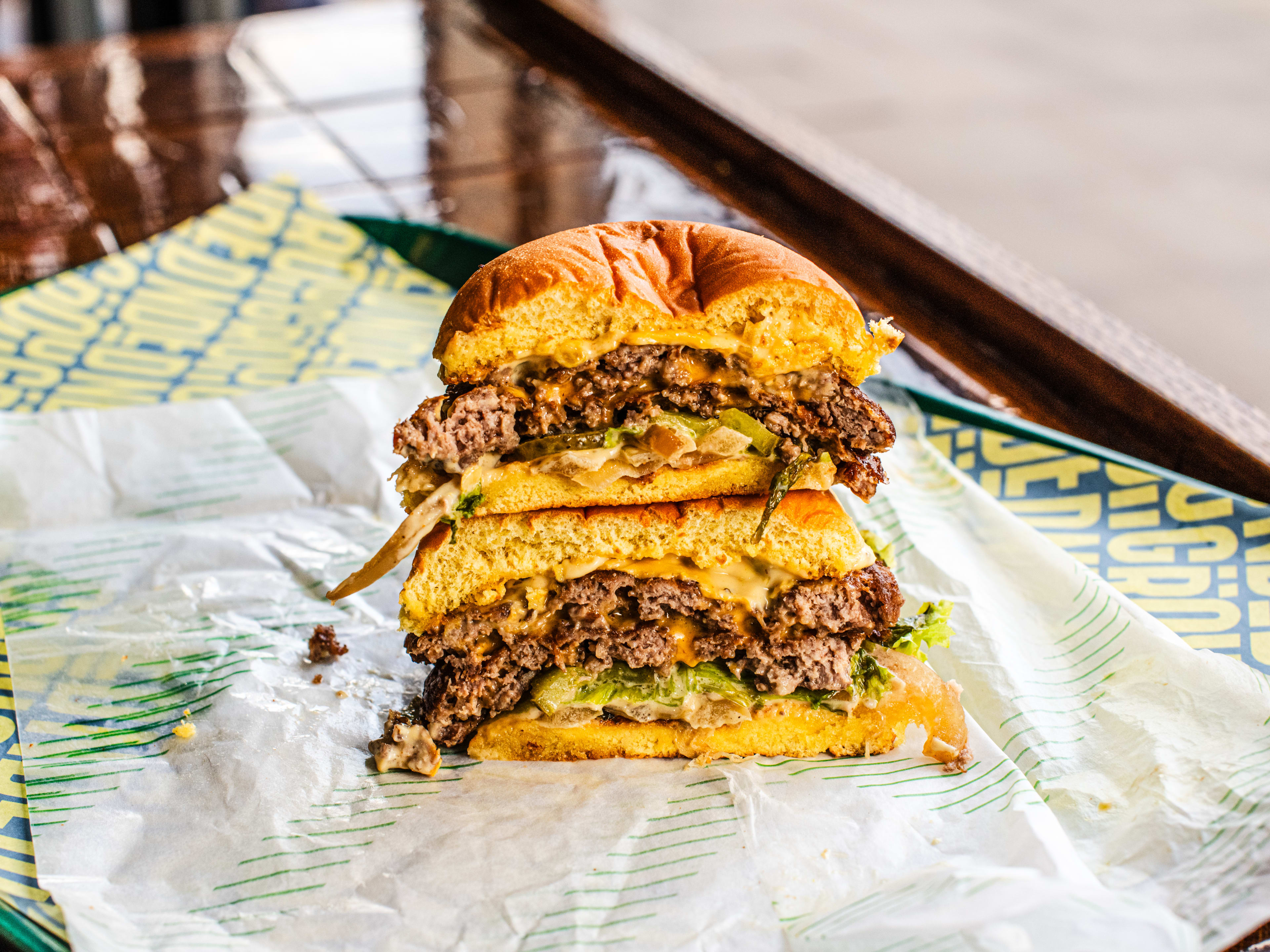 A cut-through of a beef burger, with two halves stacked on top of each other.