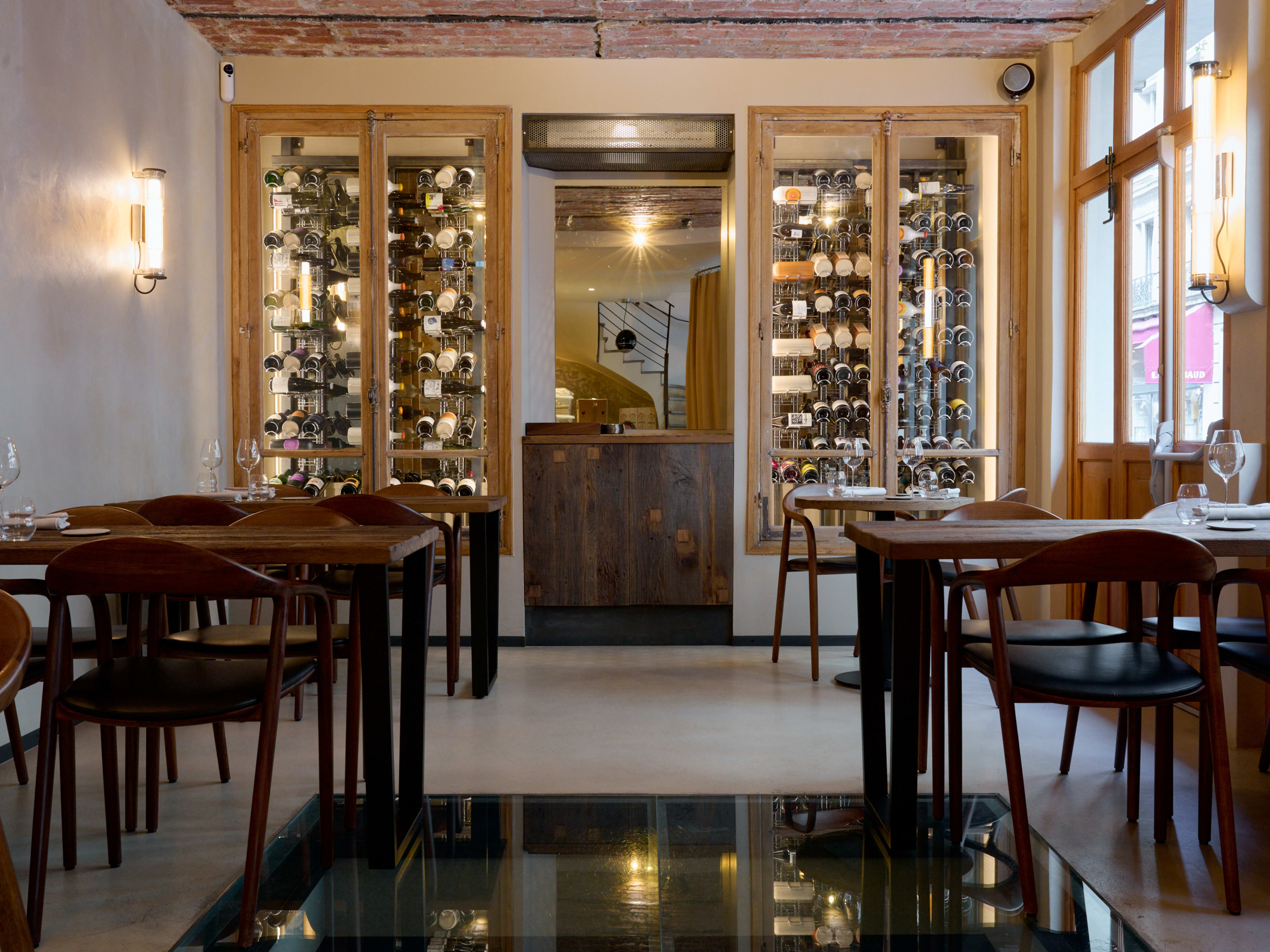 Bright interior dining room with racks of wine bottles at Géosmine