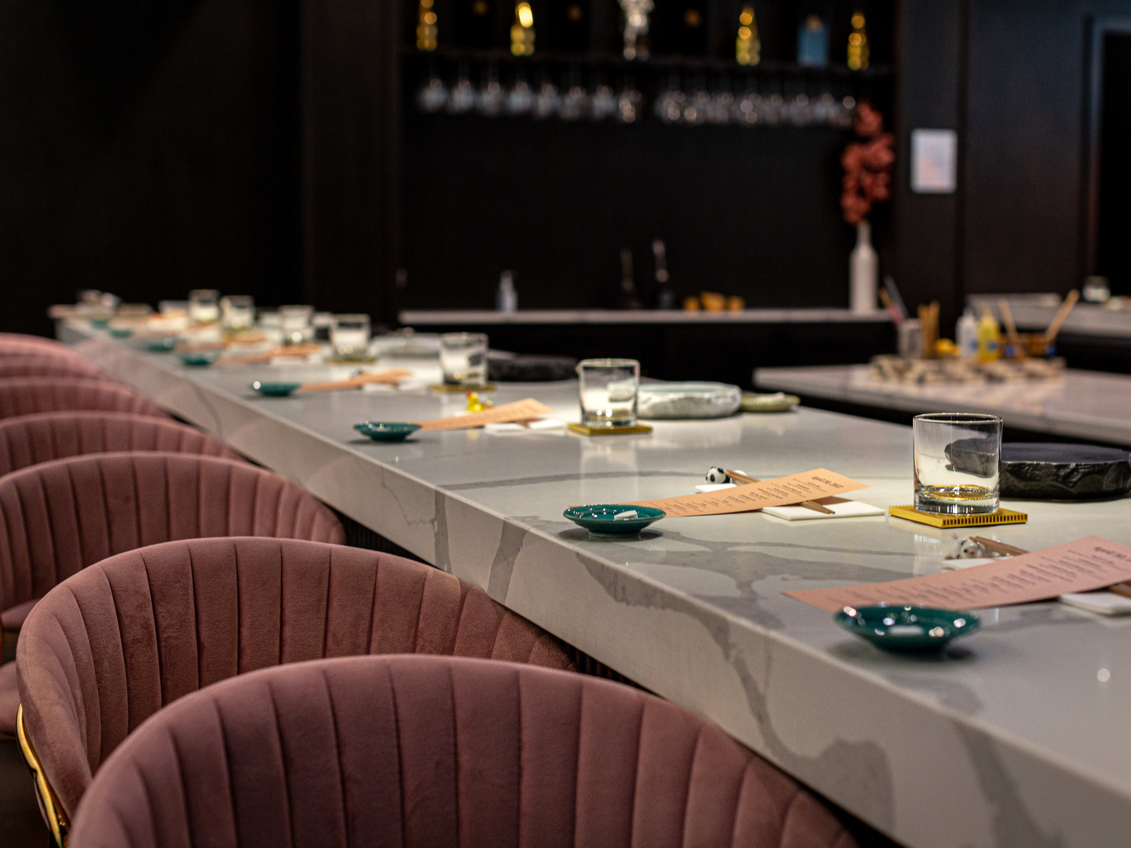 marble bar set with menus plated and tufted pink barstools