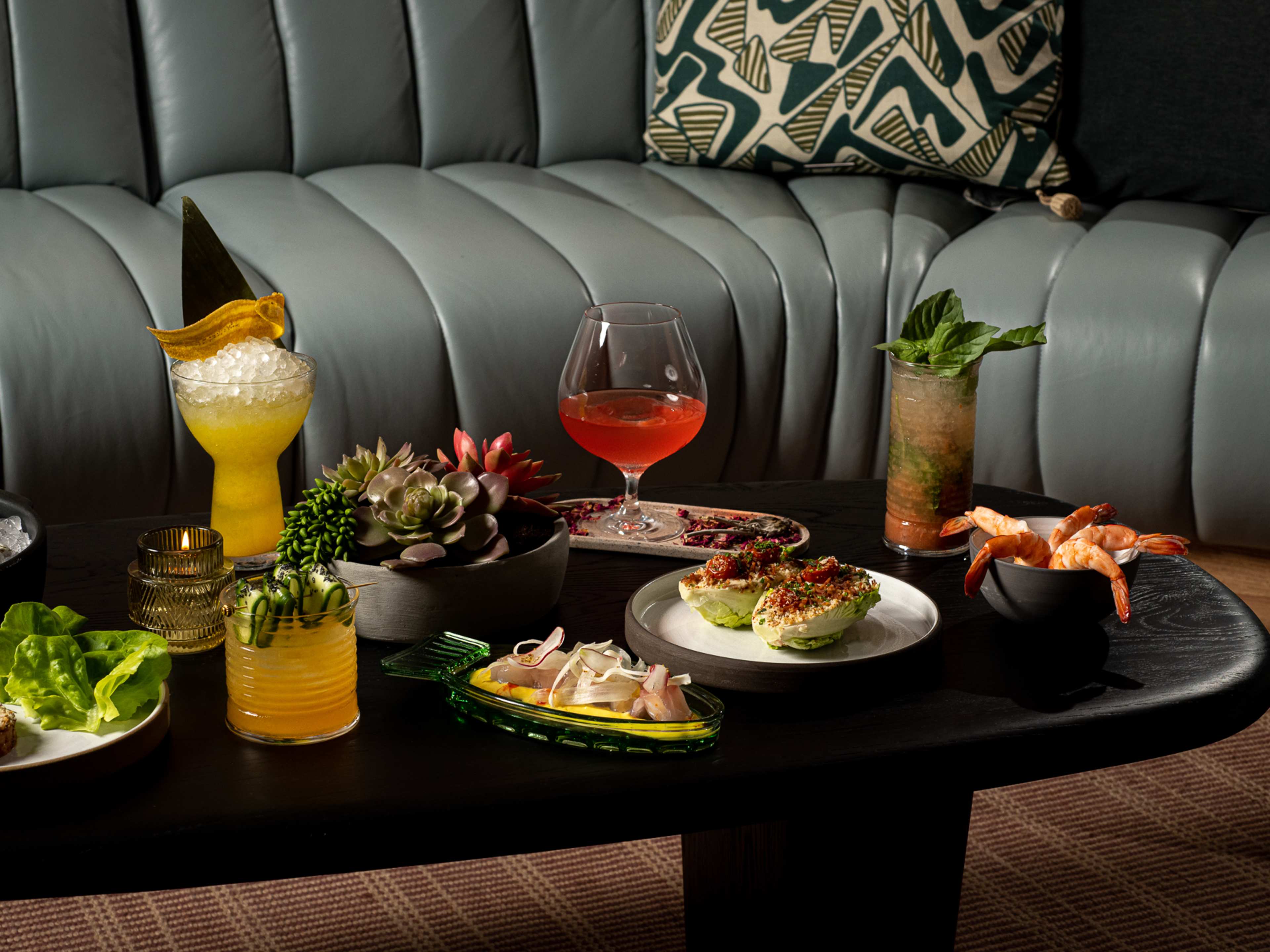 spread of bar bites and cocktails on small coffee table