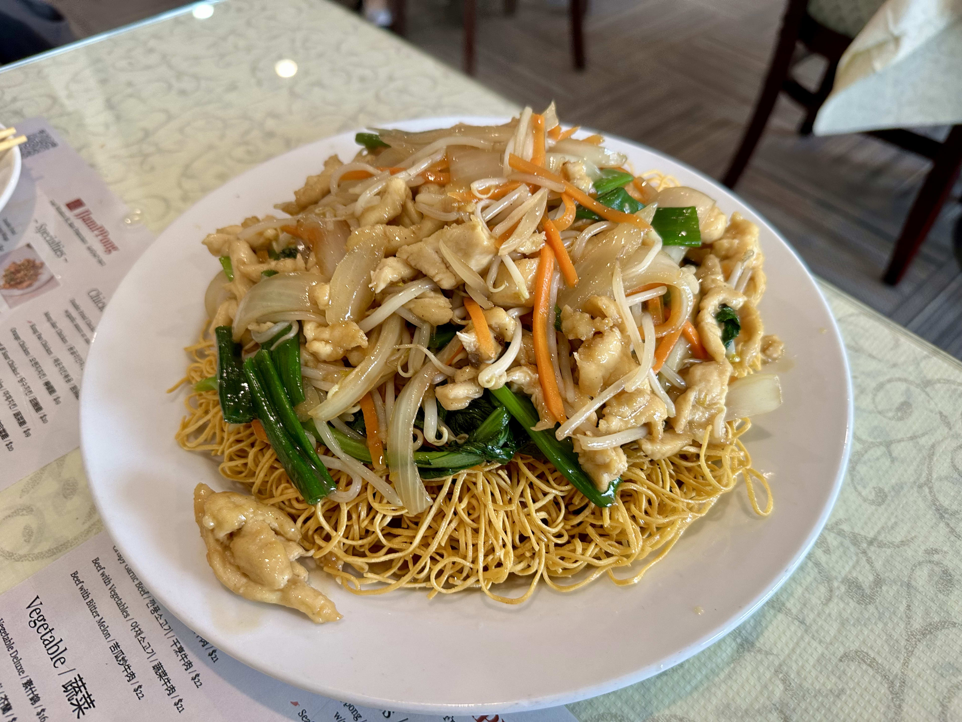 super thin noodles piled on plate and topped with chicken and veg