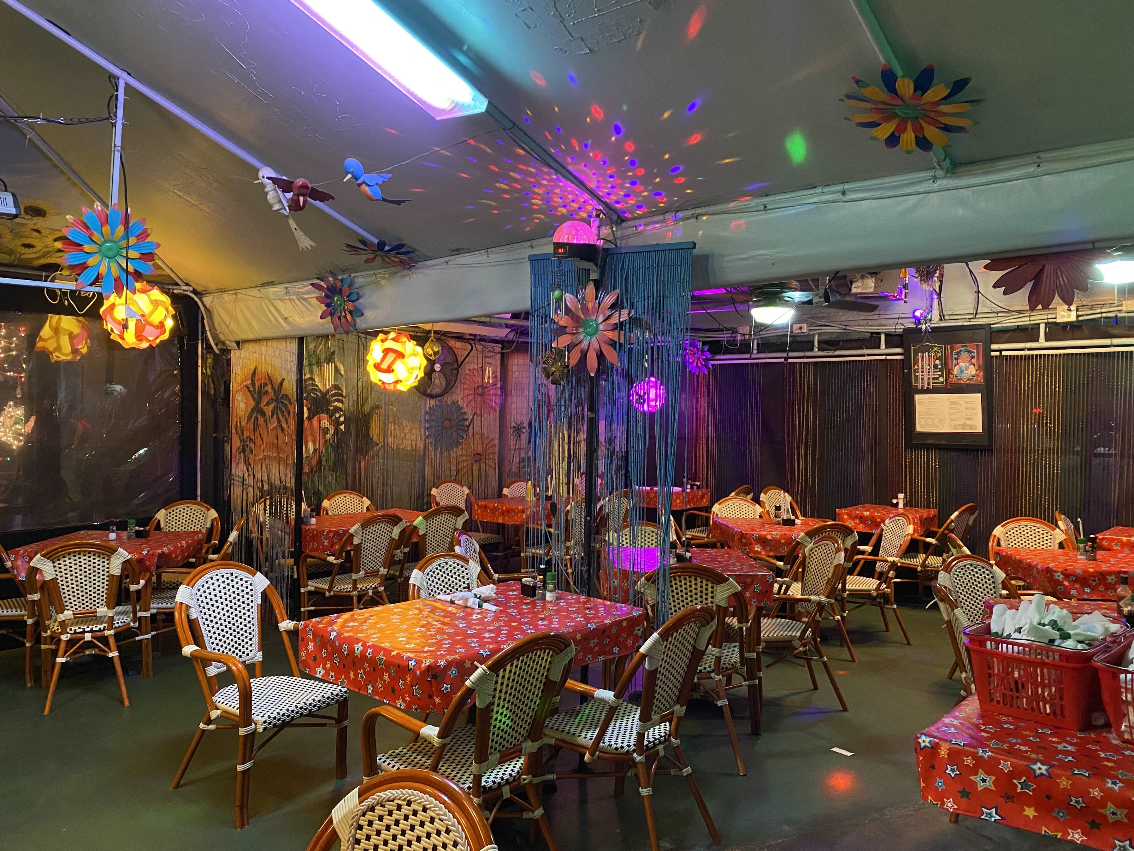 nighttime shot of outdoor covered tent with tables and chairs