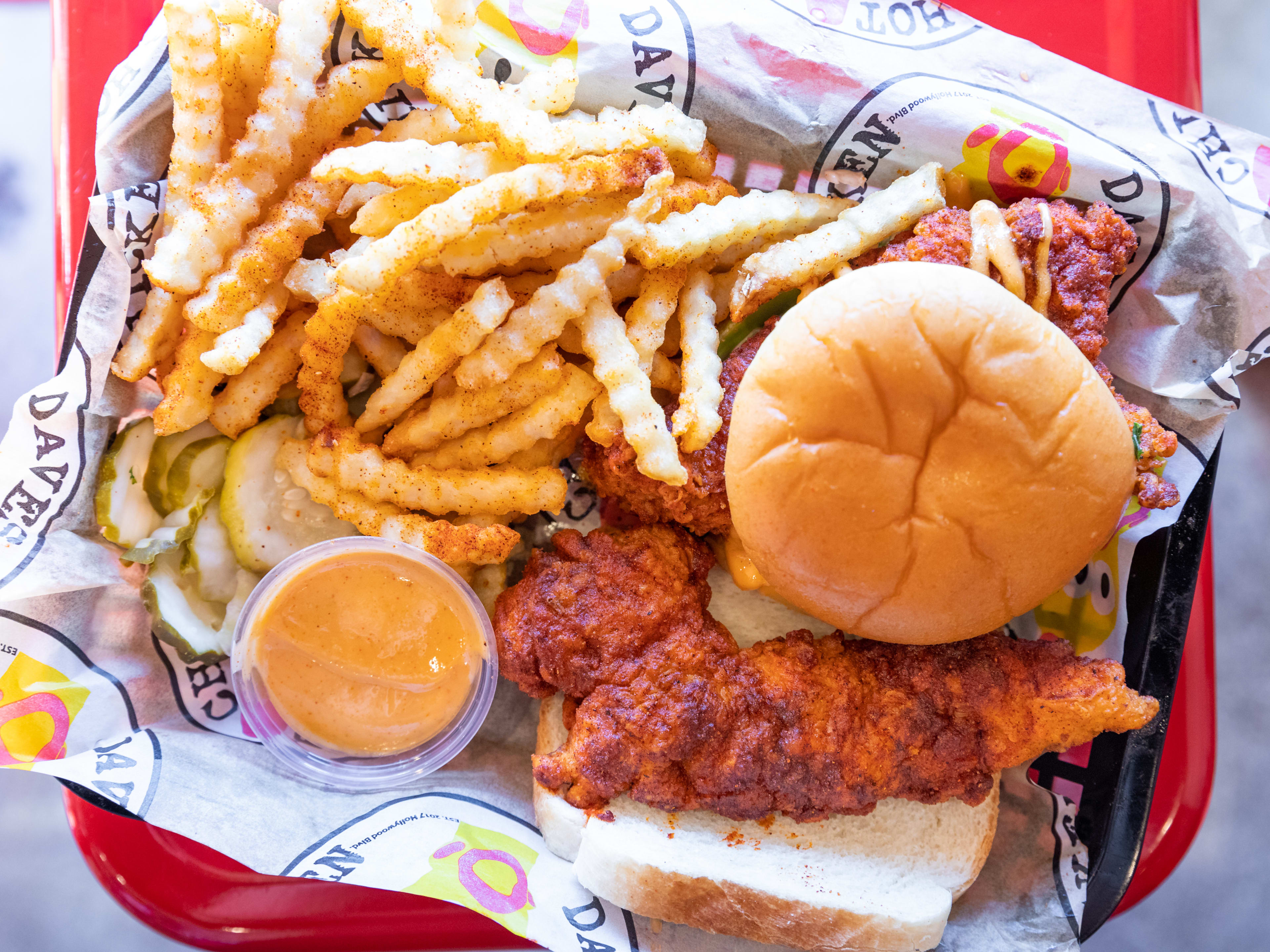 A Nashville-style chicken slider with a side of fries, pickles, and aioli.