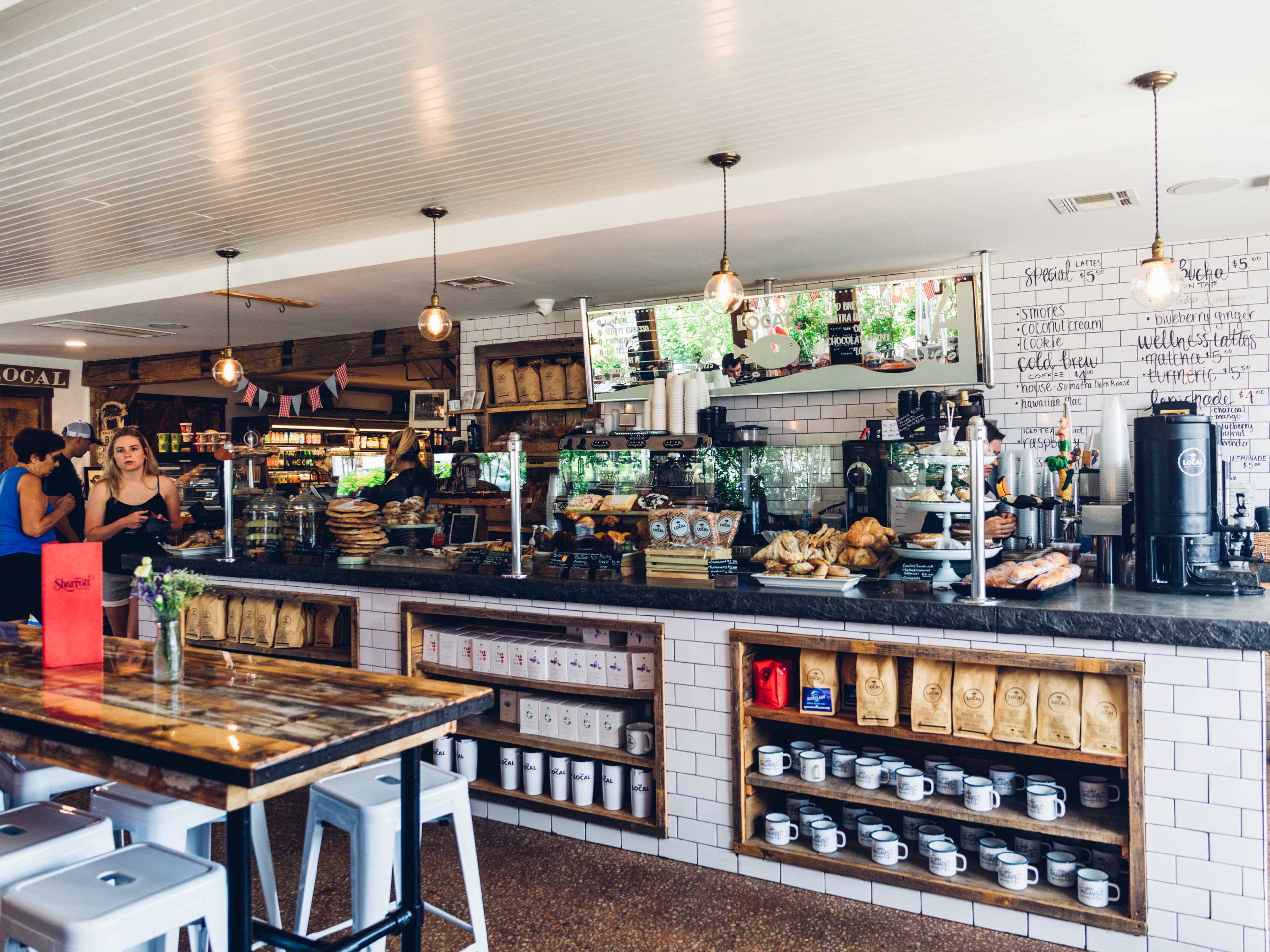 The Local interiors with white tile walls and pastries behind glass on the counter