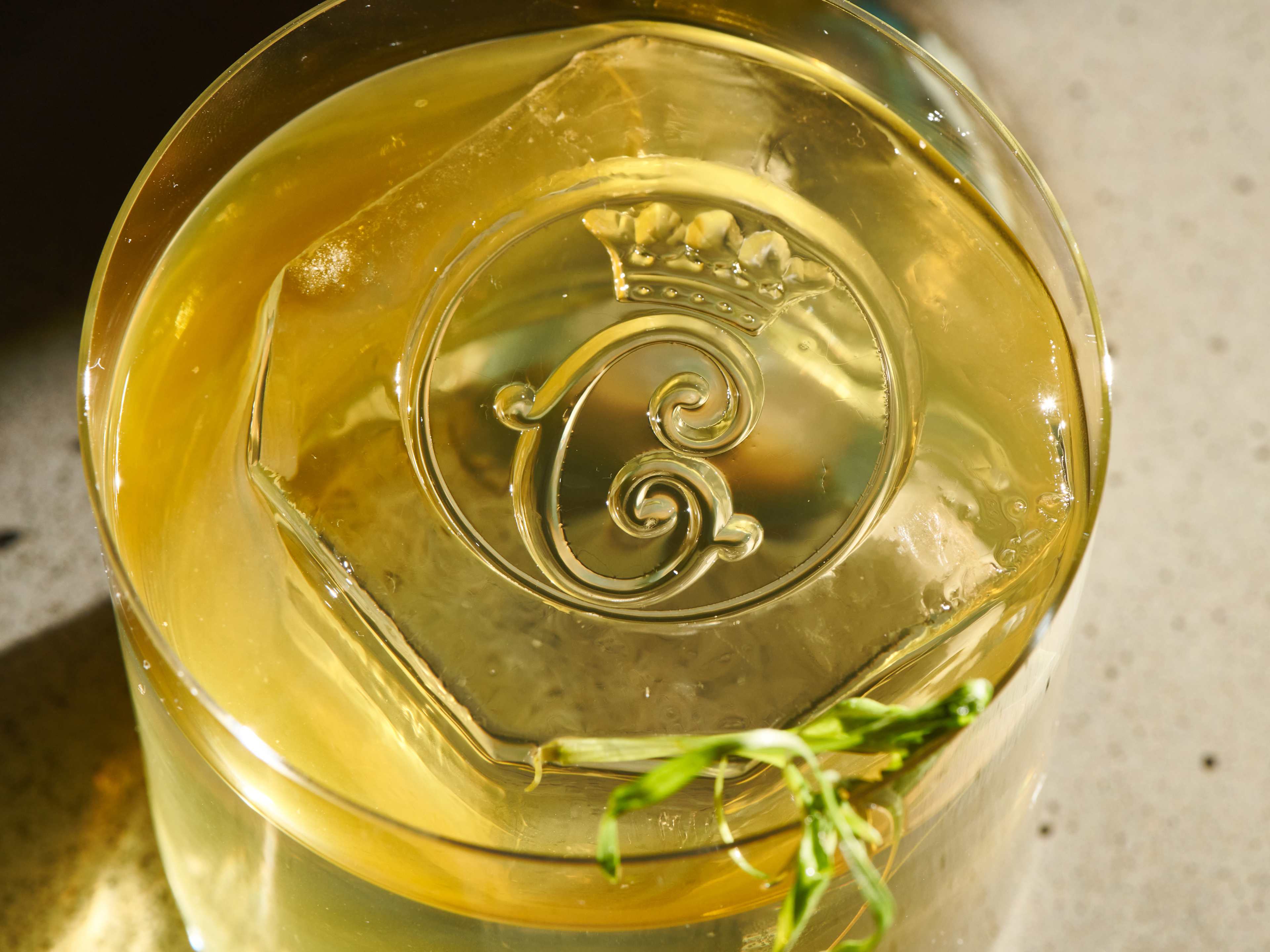 Cocktail with monogrammed ice cube at Bar Les Ambassadeurs