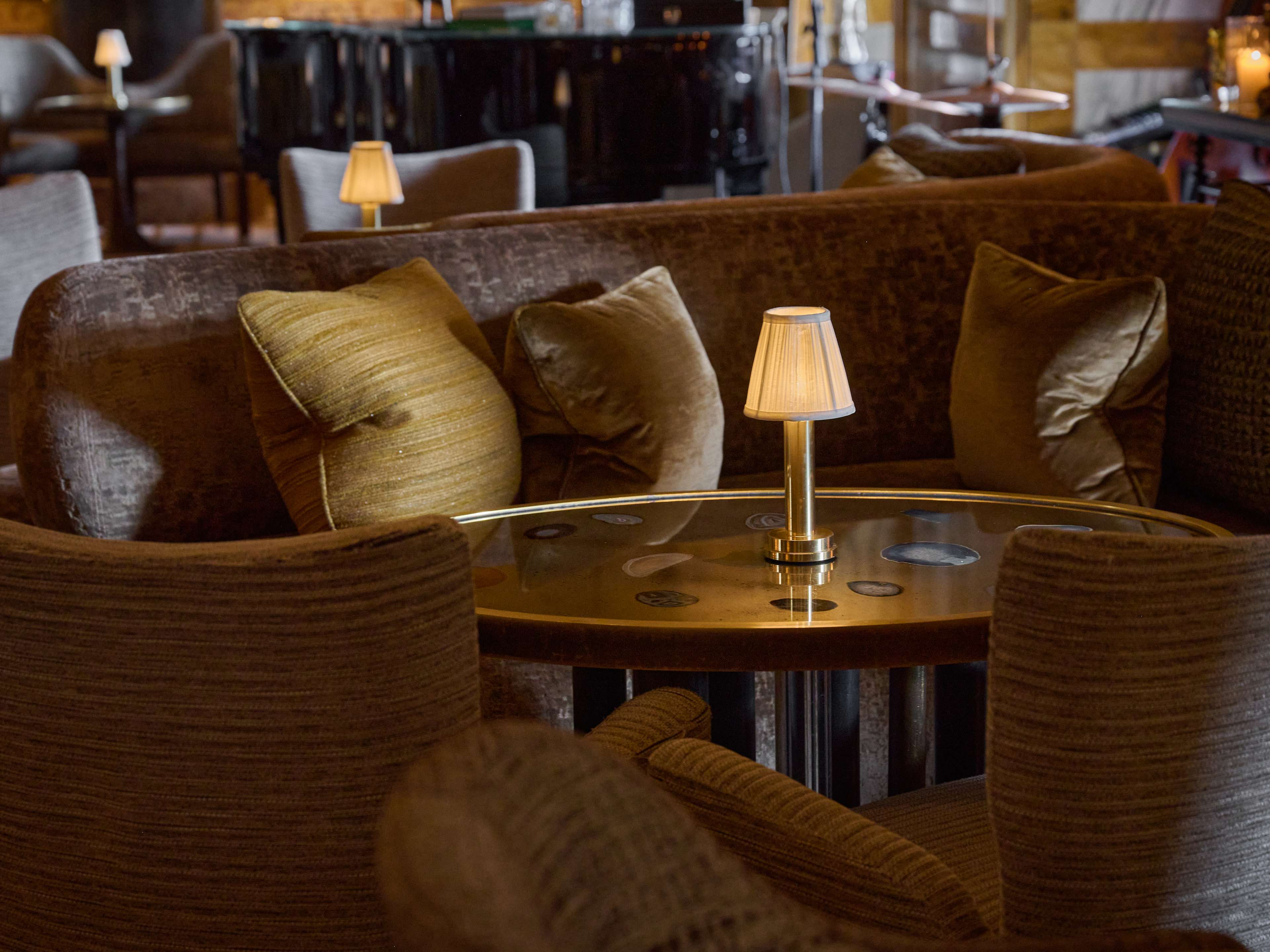 Interior lounge area with golden lighting at Bar Les Ambassadeurs