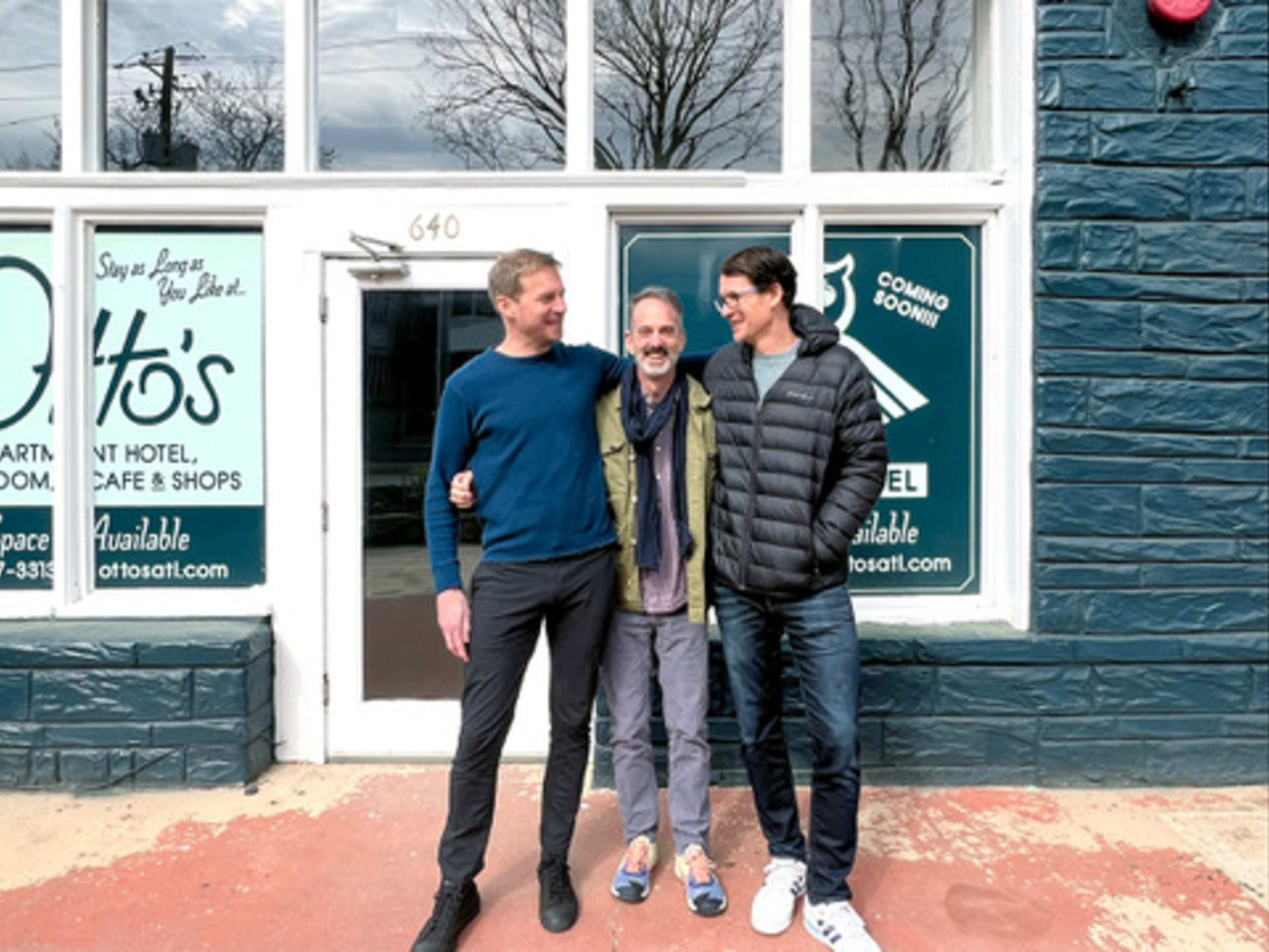 Owners Steven Satterfield, Neal McCarthy and Tim Willard standing in front of a teal building.