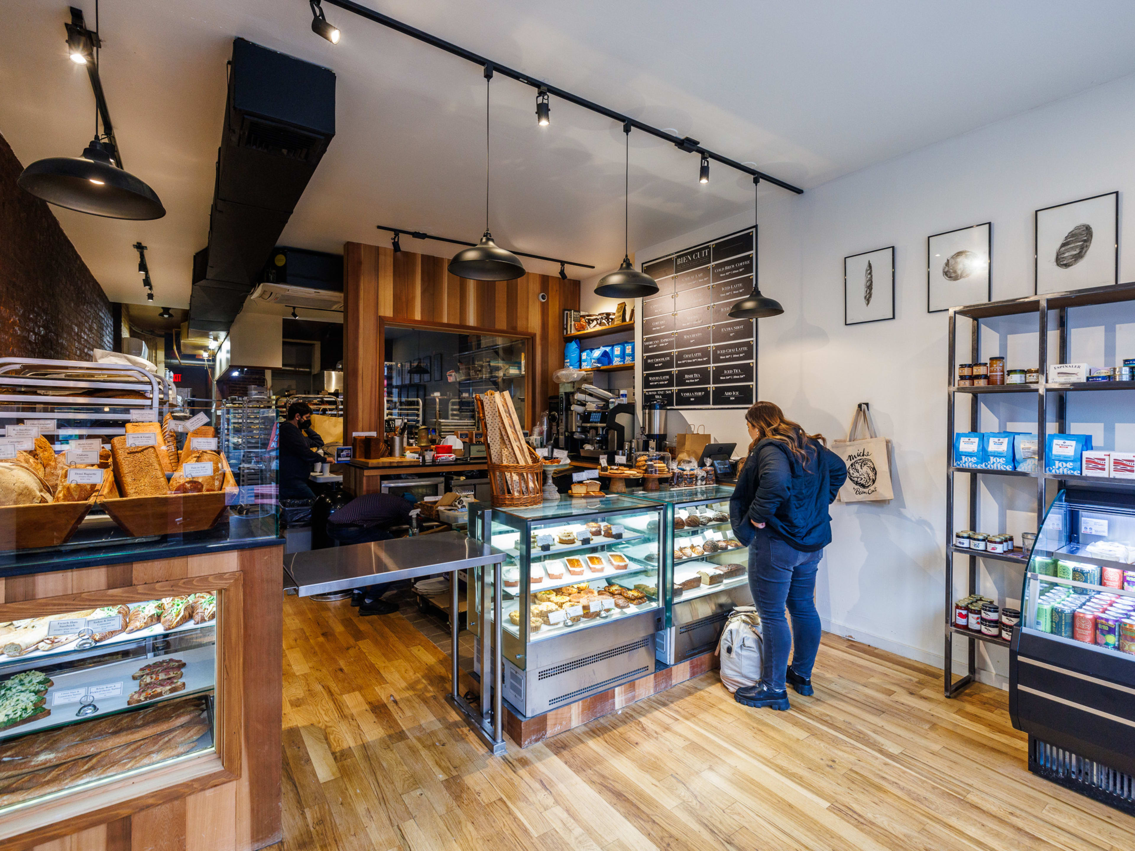 Bien Cuit interior with baked goods in a display case and a customer ordering at the counter